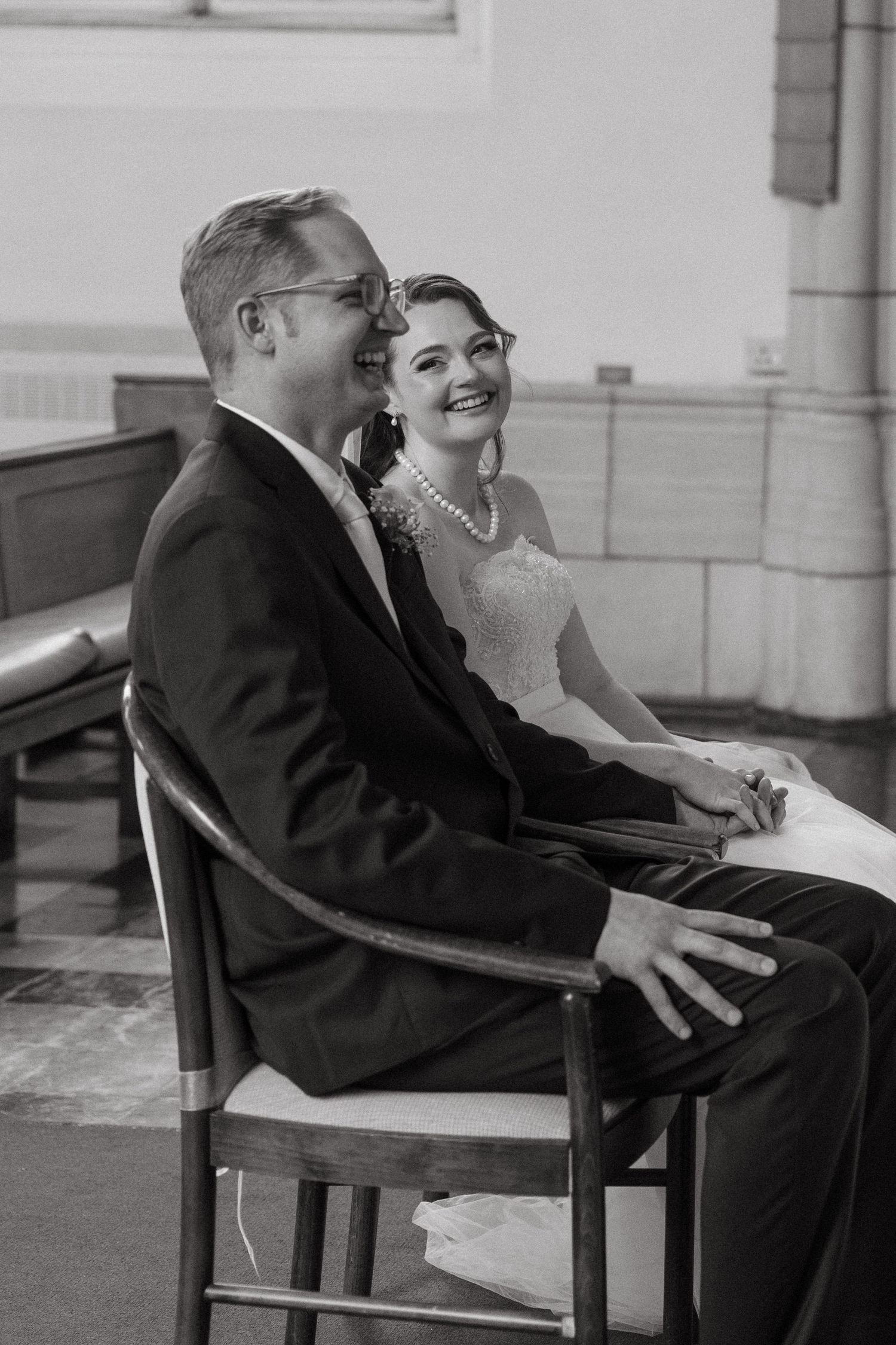 A bride and groom share a laugh during a Catholic wedding ceremony at Nazareth House Chapel