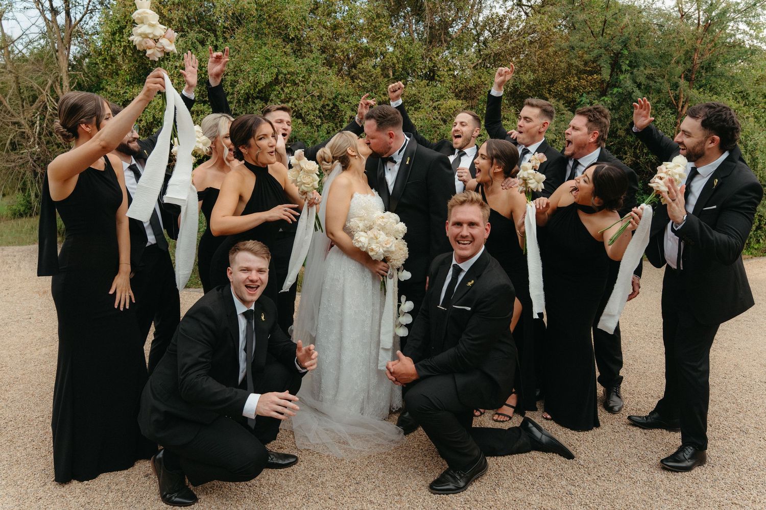 Wedding party poses together outdoors in a fun sequence of jumping and celebratory group photos.