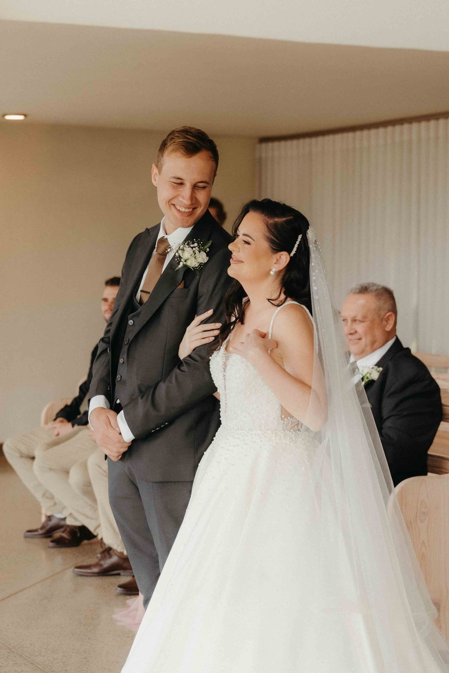 Smiling bride and groom walk down the aisle together during their wedding ceremony.