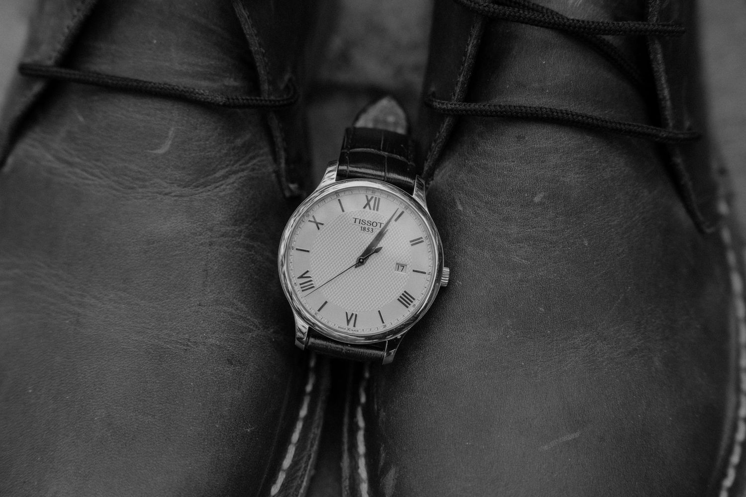 Classic analog wristwatch with leather strap displayed on dark background.