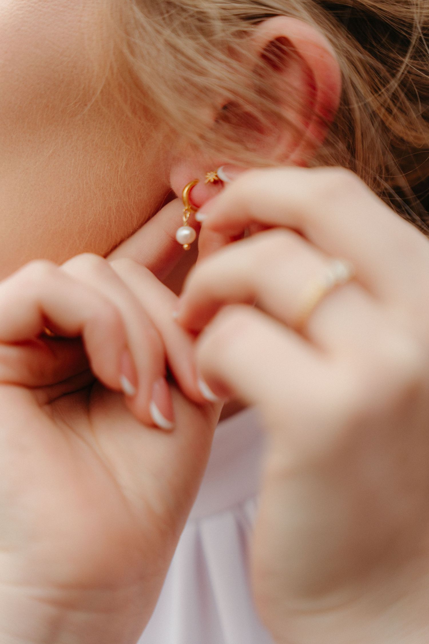 Close-up macro shot of delicate gold earrings with soft focus.