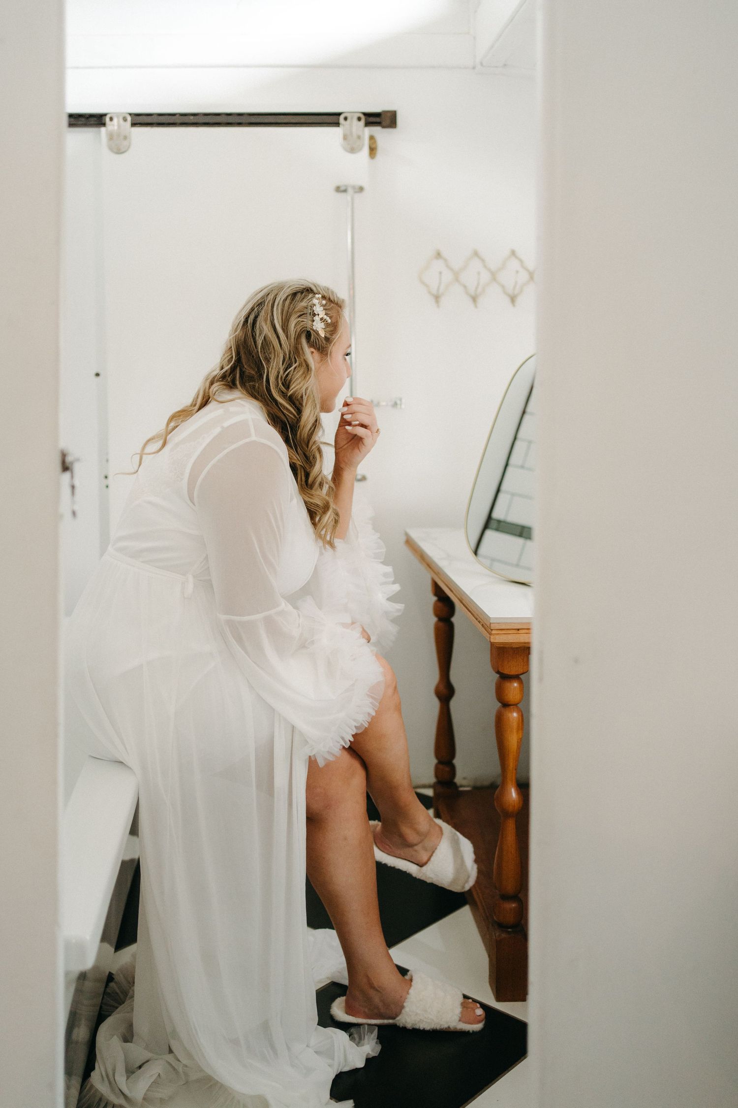 A private dressing room moment captured with soft natural lighting and white decor.