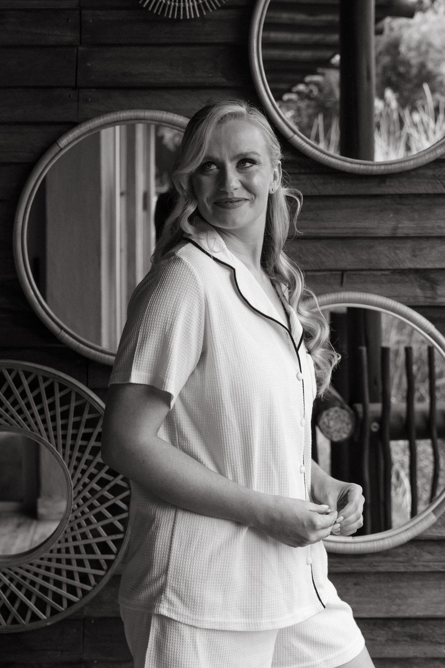 Black and white portrait of someone in white attire against vintage decor.