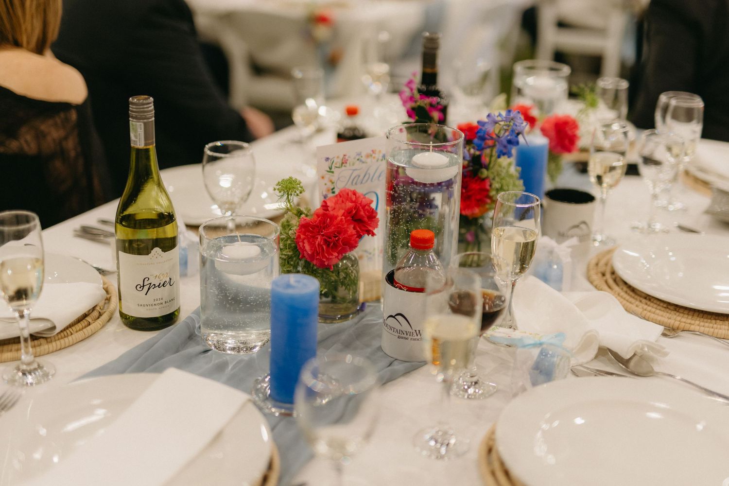 Elegant wedding reception table setting with wine glasses and colorful decorations.