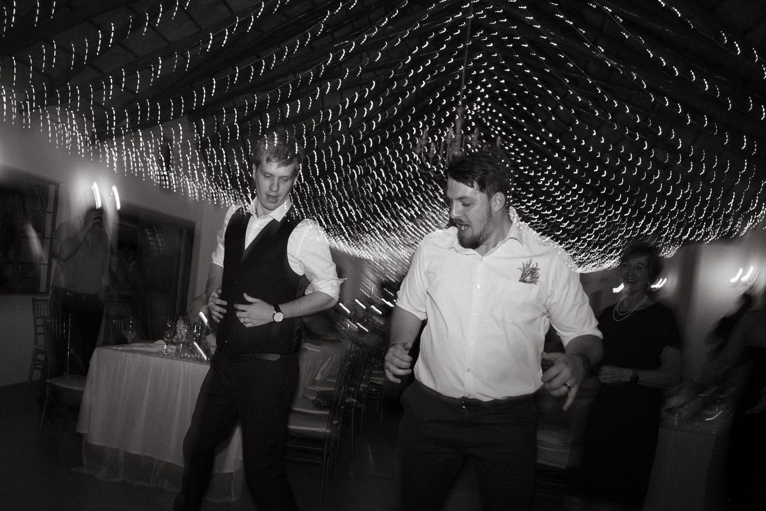 A black and white photo sequence shows people dancing and celebrating at what appears to be a wedding reception.