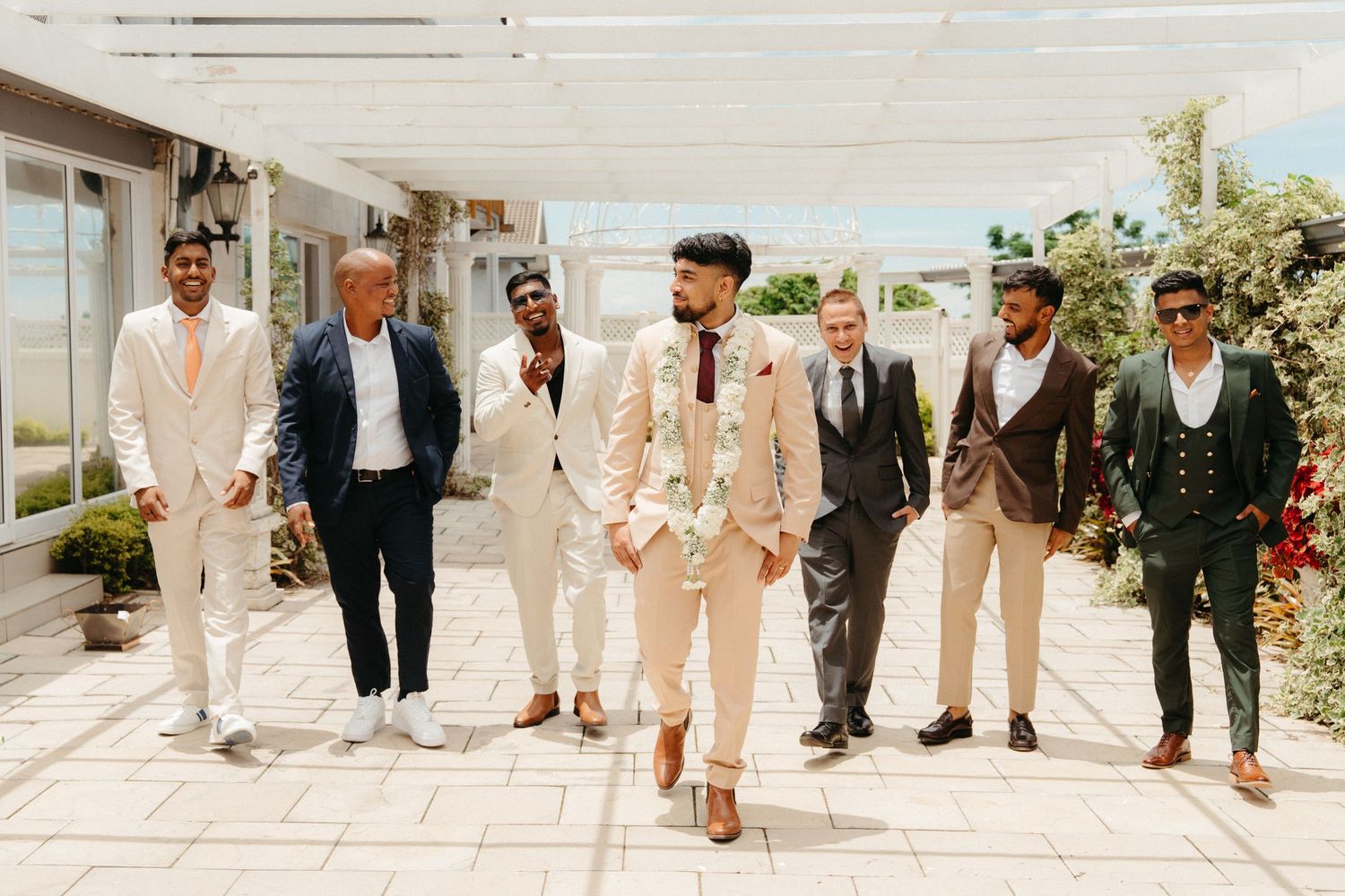 A row of groomsmen's feet showing off their colorful socks while wearing formal shoes and pants at a wedding.