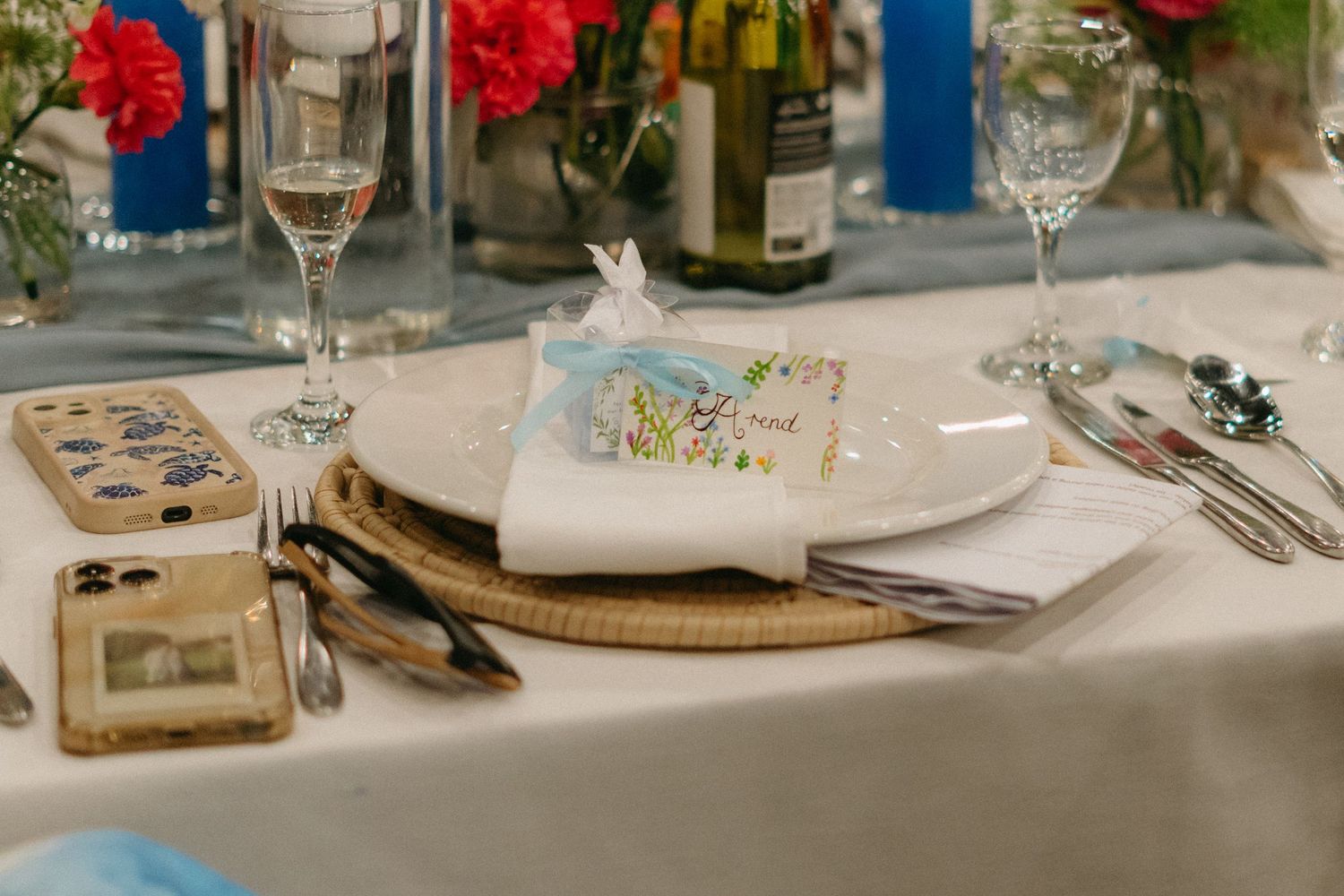 Elegant wedding table setting with glassware, flowers, and place settings at reception.