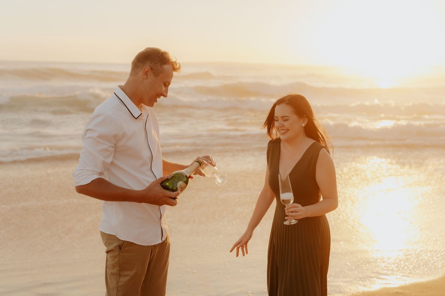 Romantic couple sharing intimate moments on sandy beach during golden hour.