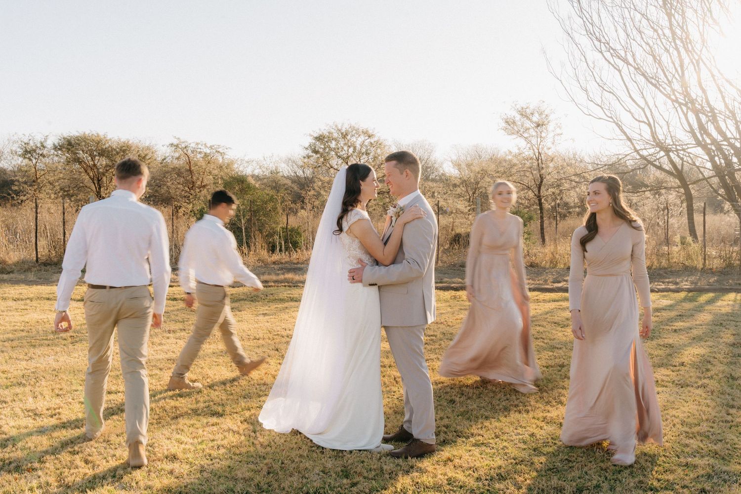 Candid moments of wedding party celebrating in light-colored attire during sunset.