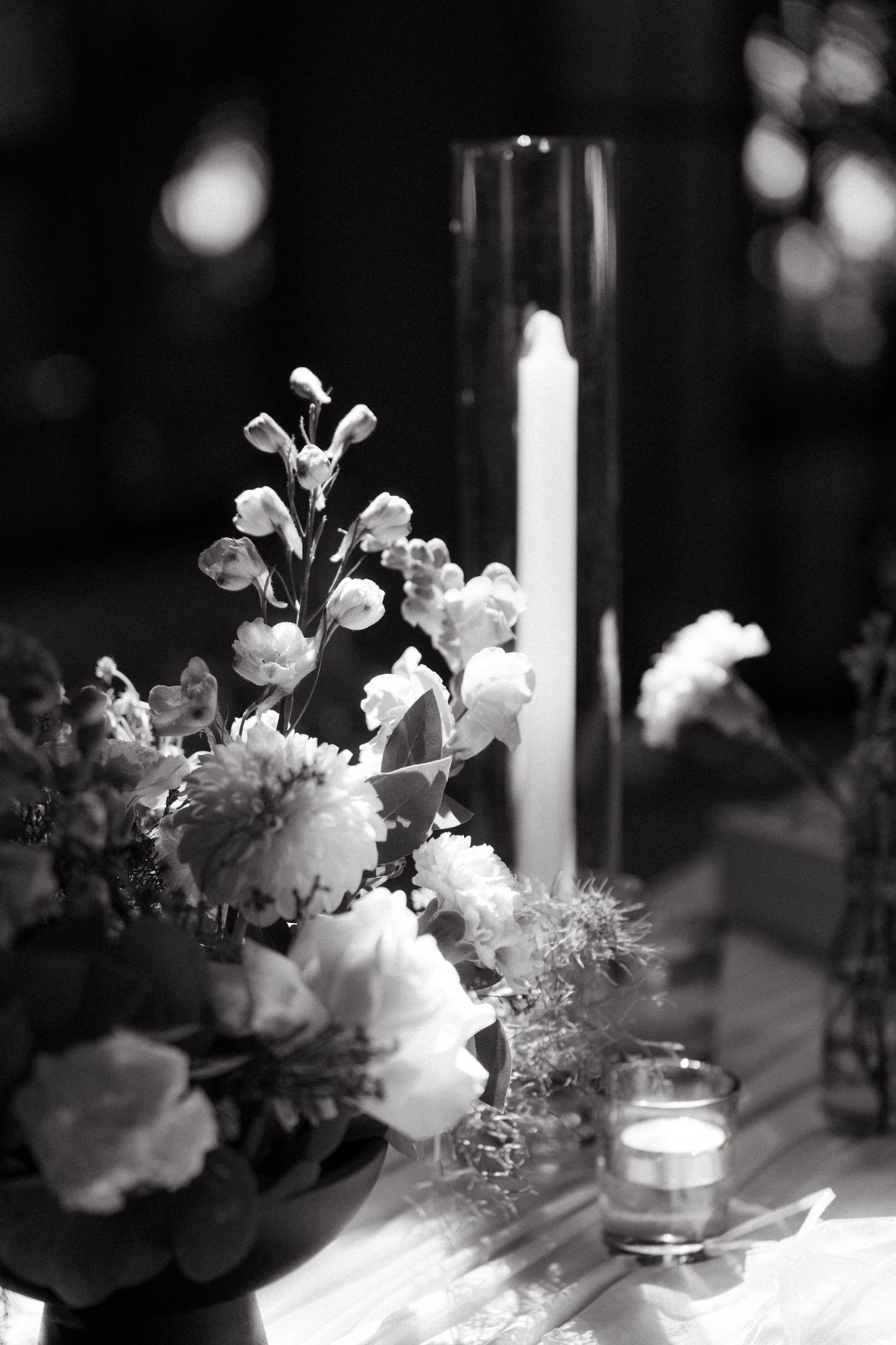 Elegant wedding table centerpiece at Oakfield Farm with white flowers and tall candles in black and white.