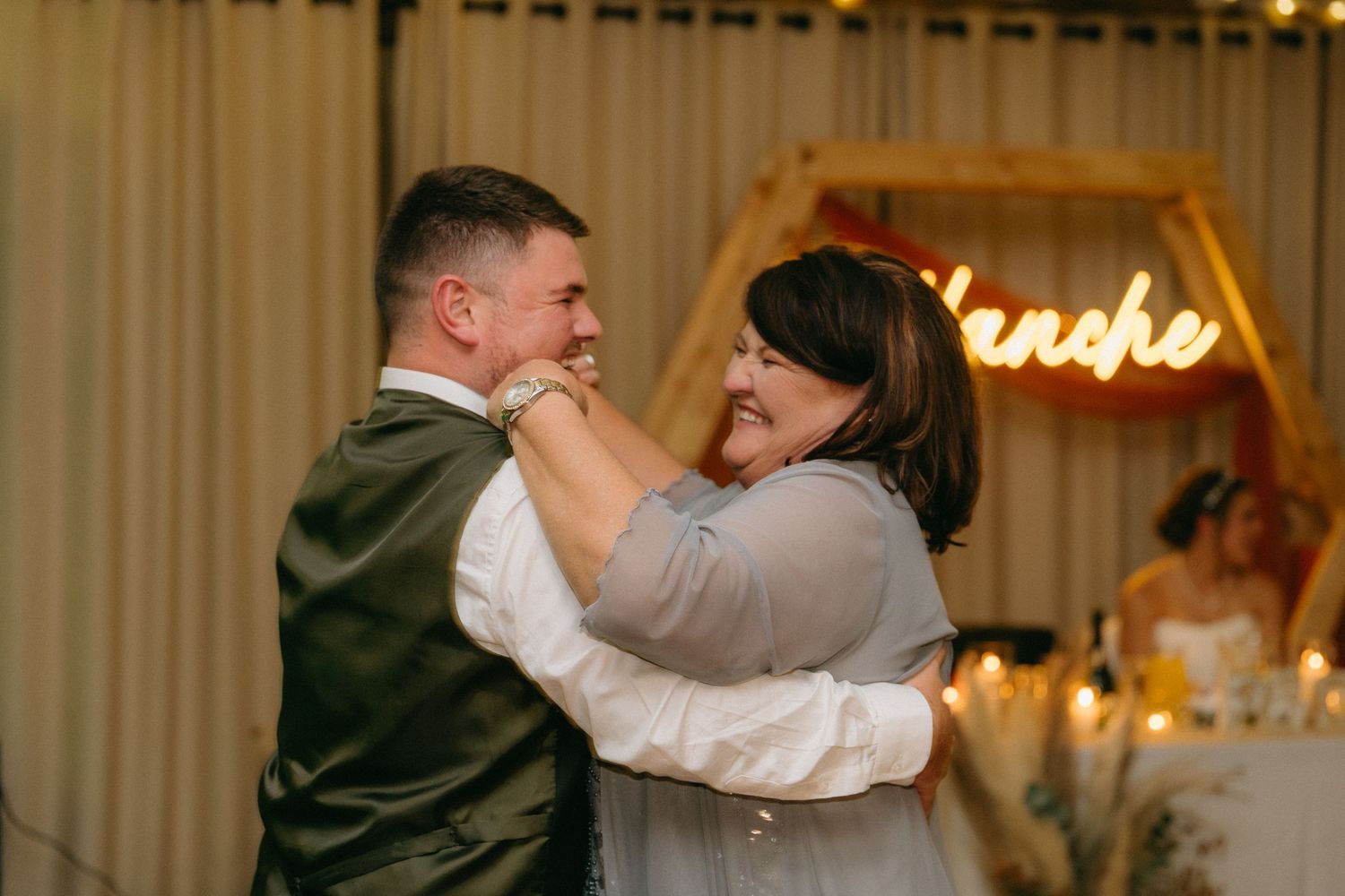 Couples dancing together at an elegant wedding reception with warm lighting.