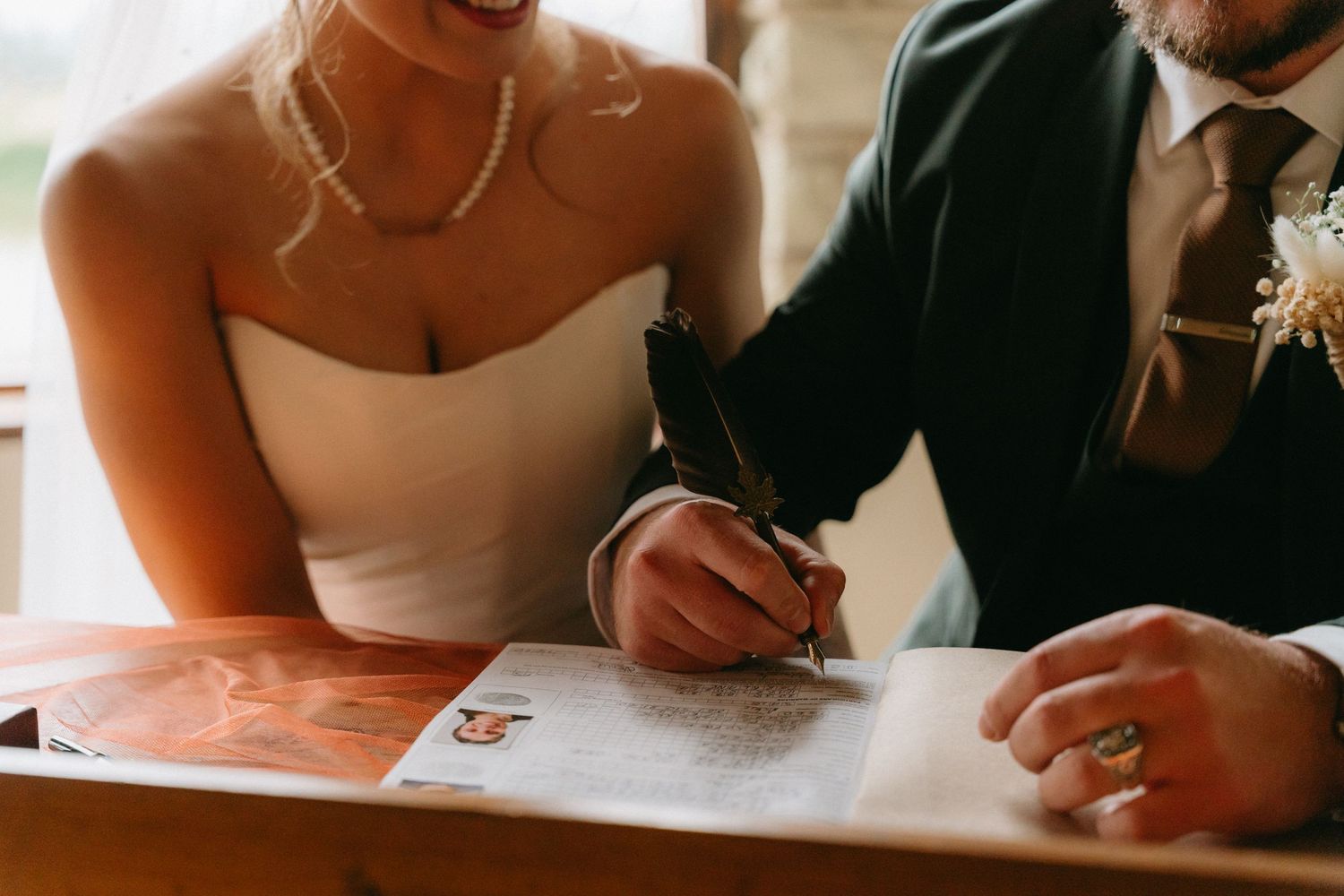 Intimate moment of couple signing marriage documents together.