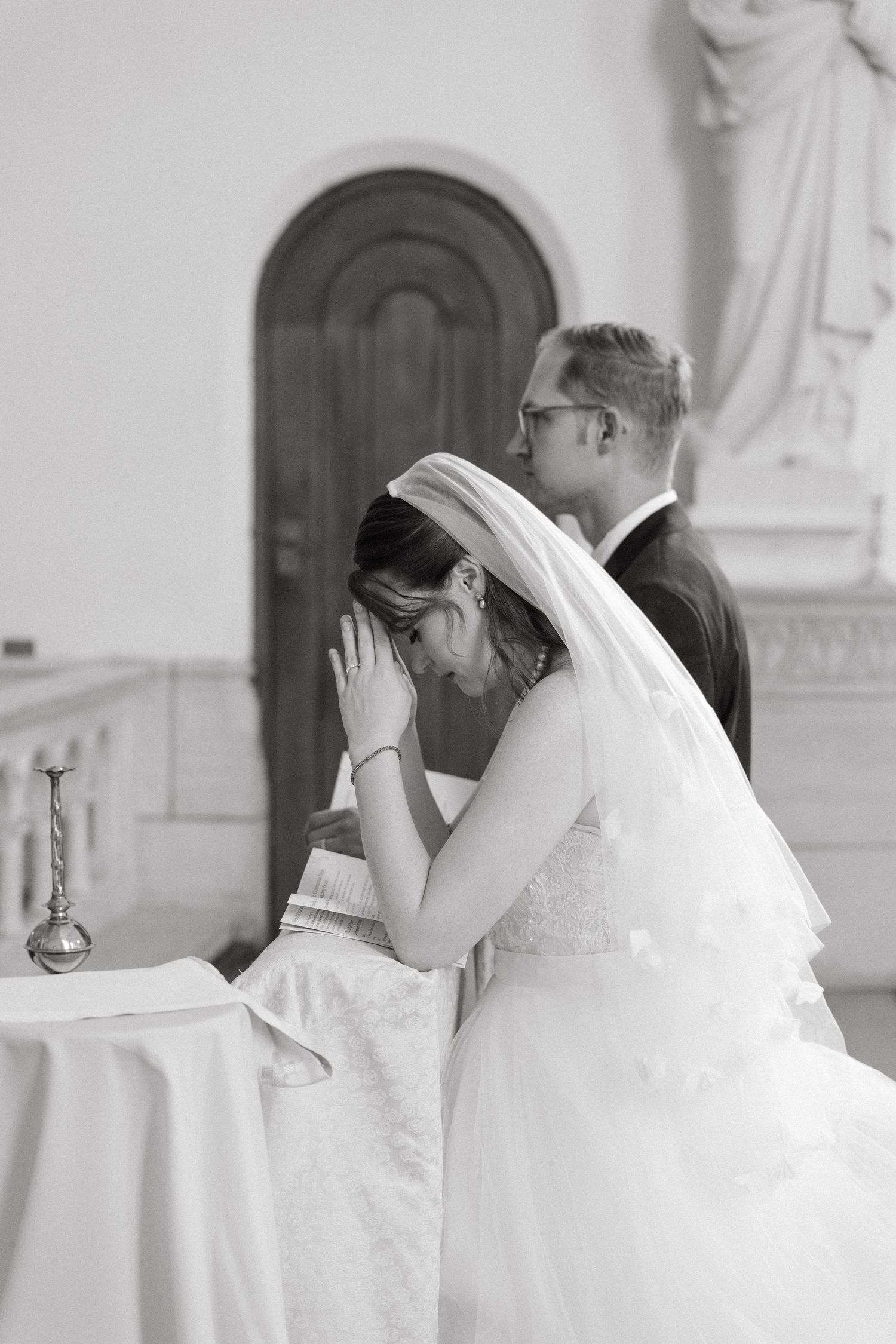 A bride kneels in prayer during a Catholic wedding ceremony at Nazareth House Chapel in Pretoria