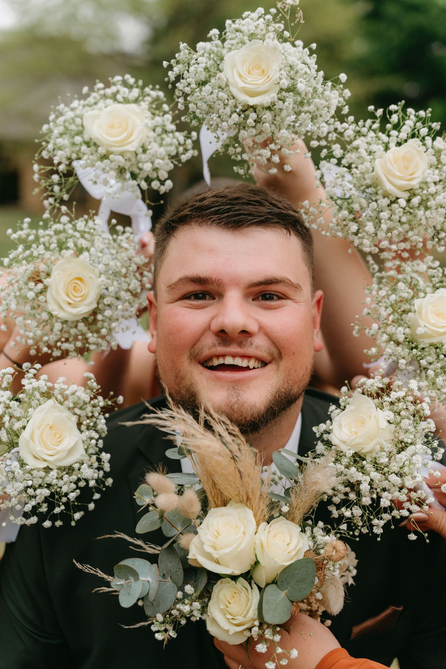 White roses and baby's breath floral arrangement with eucalyptus leaves decorates wedding celebration.