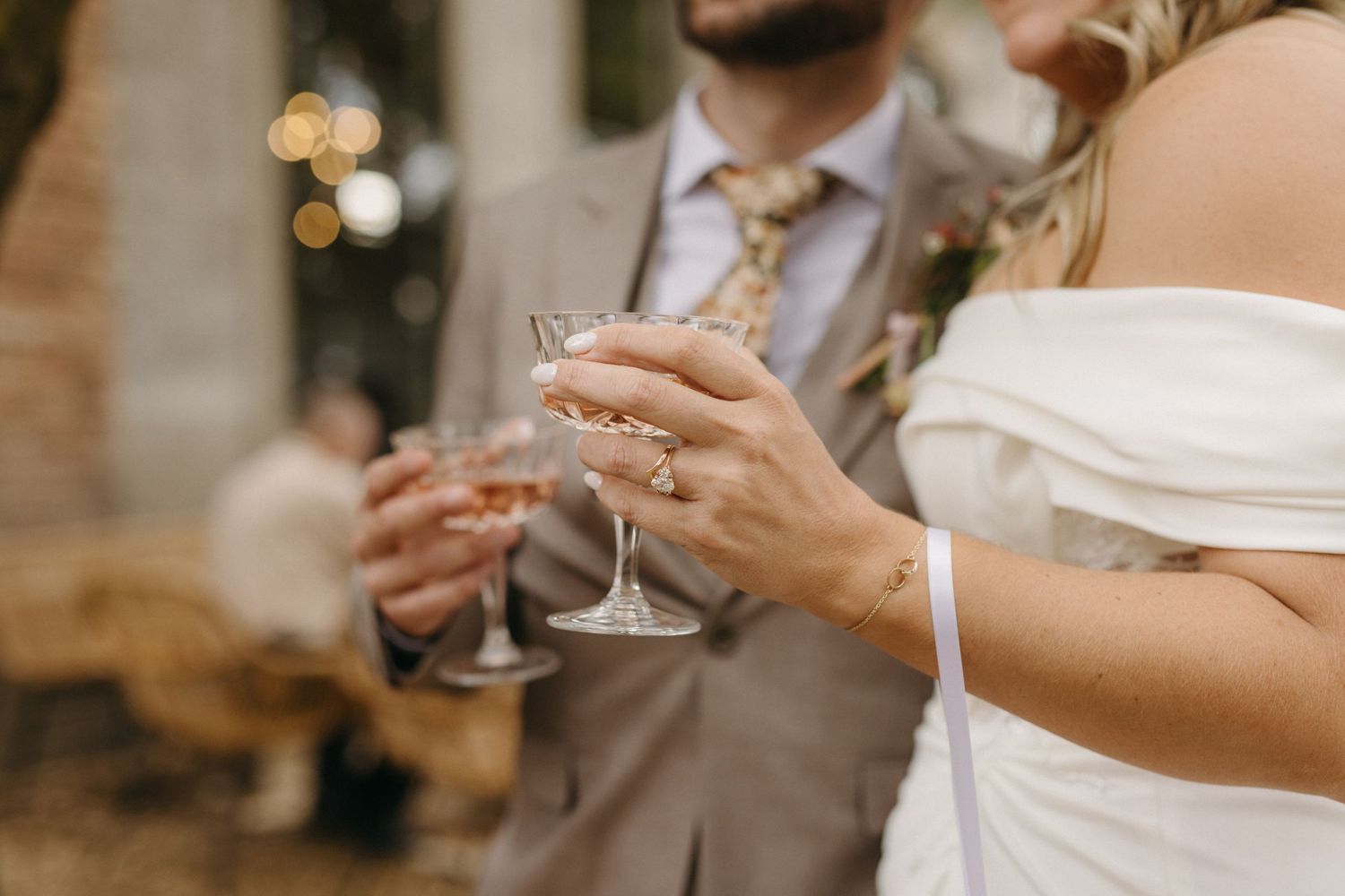 Close-up of couple holding champagne glasses during wedding toast.