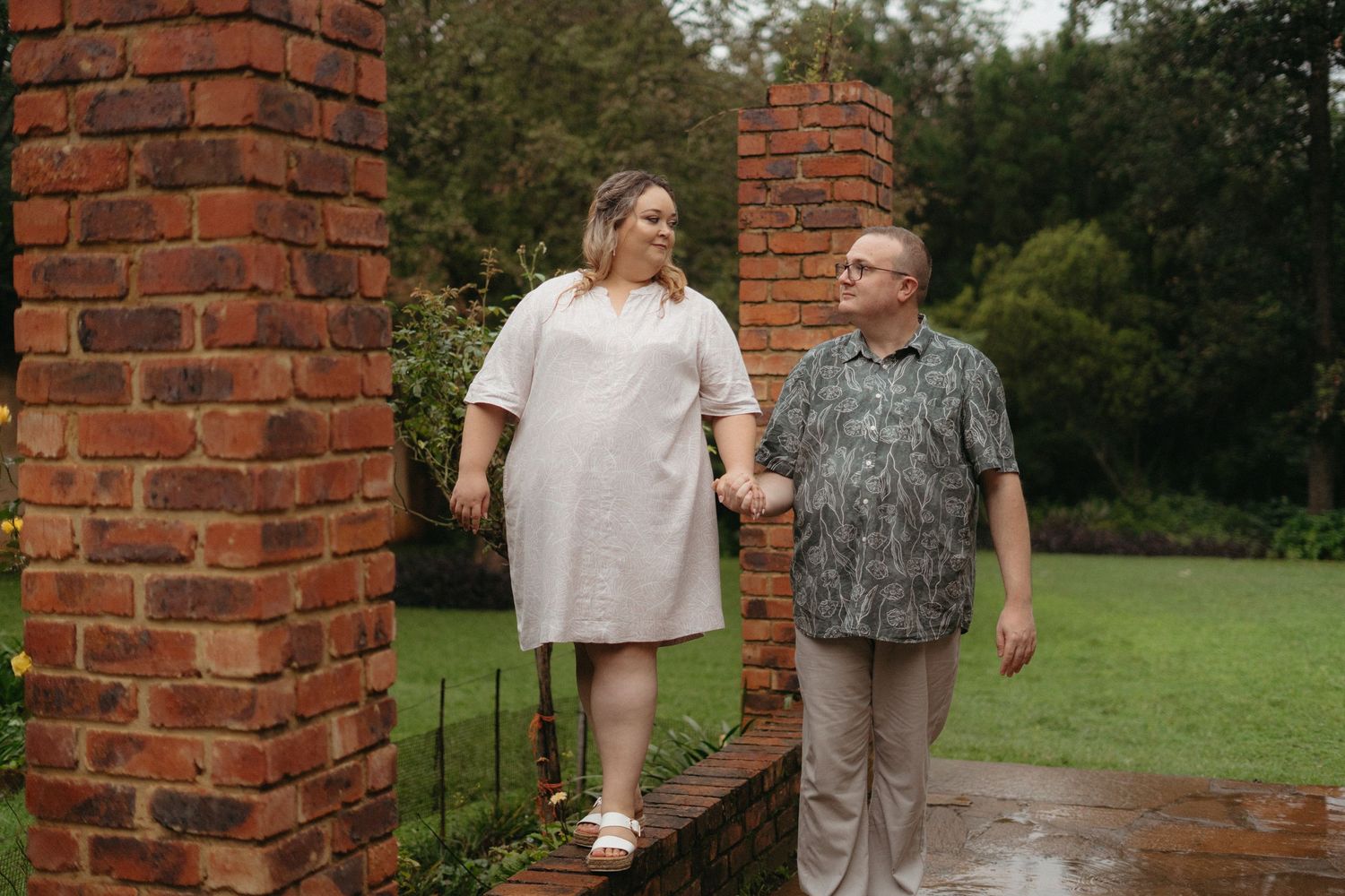 A romantic couple embracing during golden hour in a natural outdoor setting.