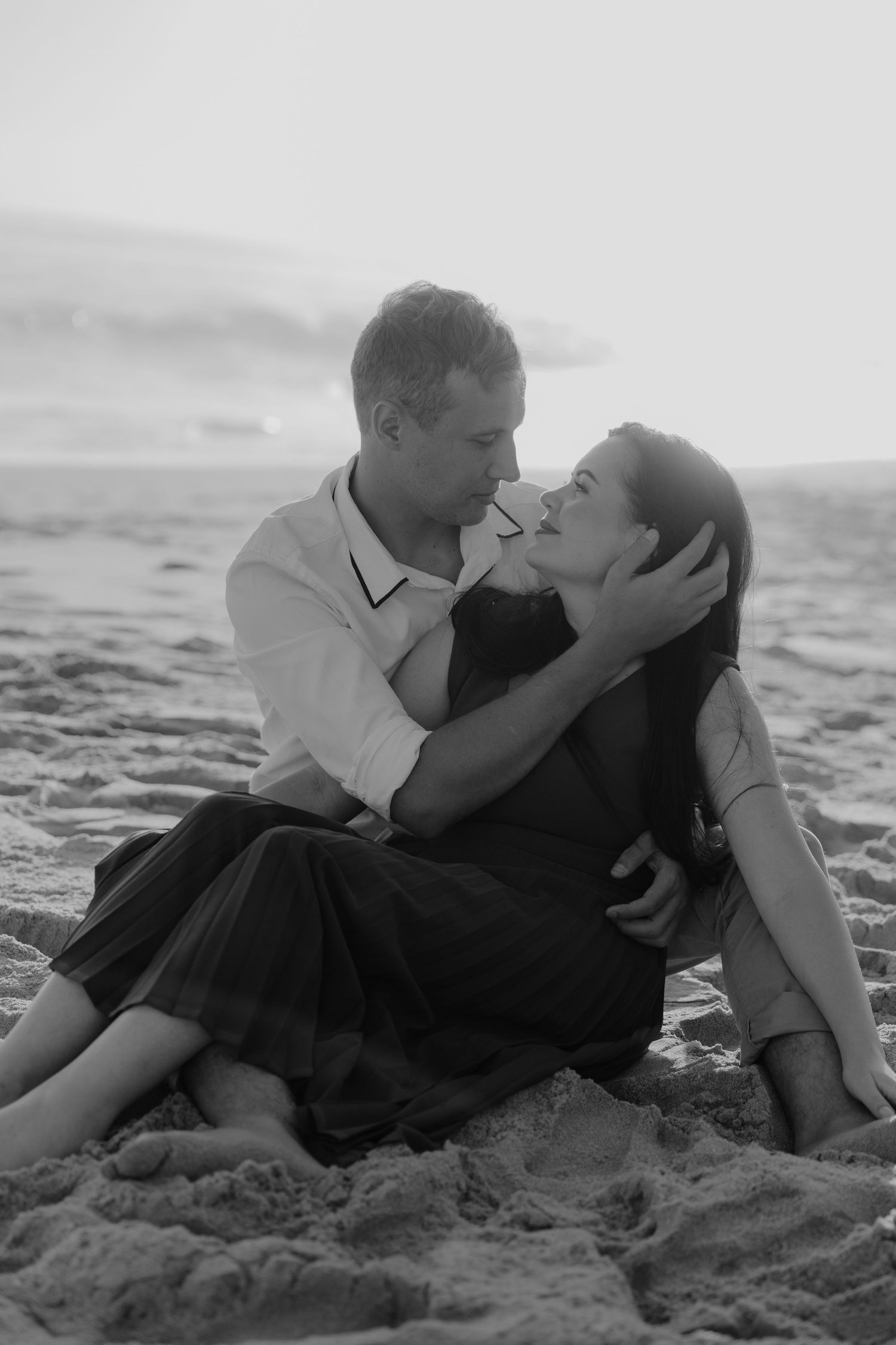 A romantic couple embraces on a sandy beach in Mossel Bay, South Africa