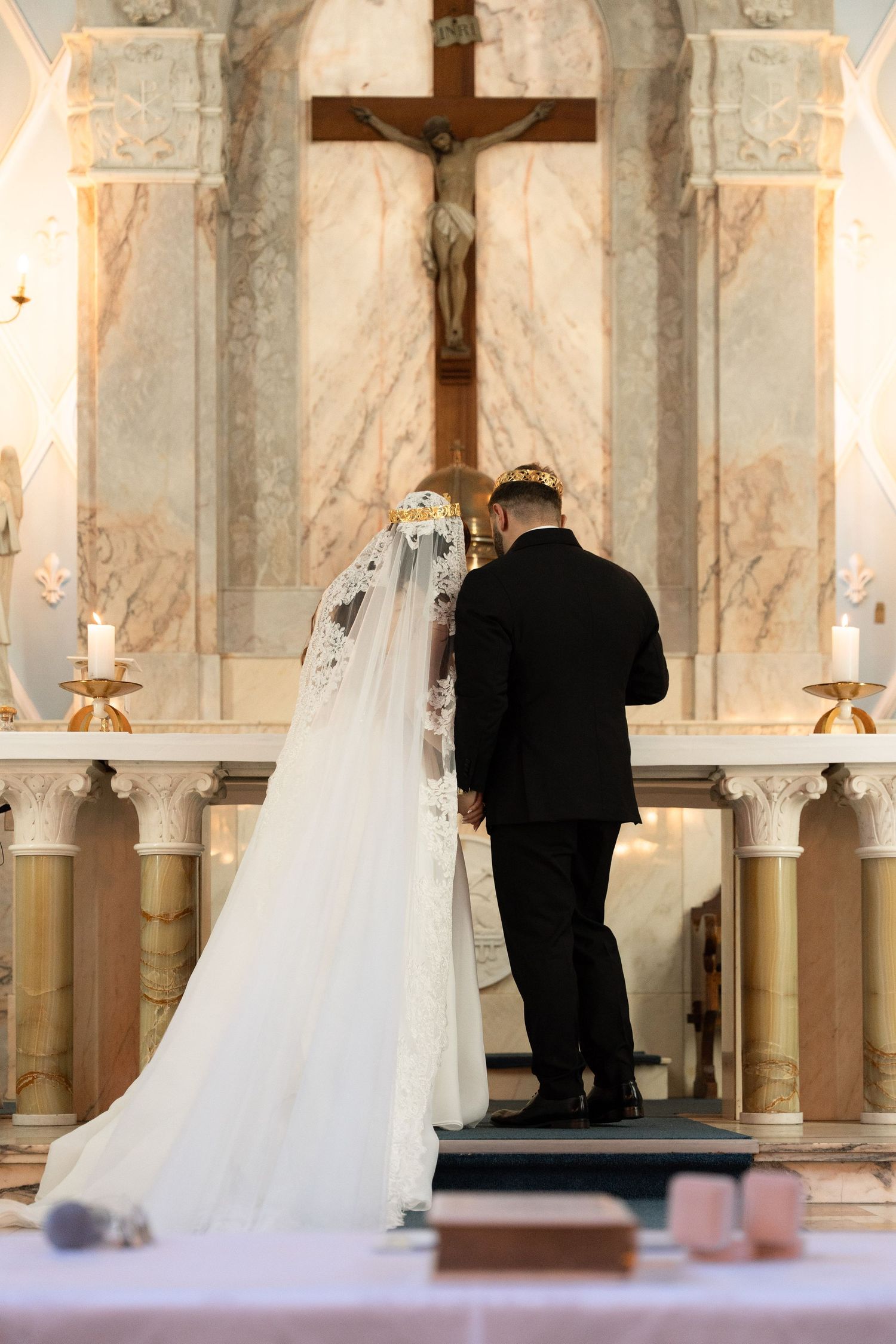 Bride and groom standing at church altar before crucifix during traditional Catholic wedding ceremony at Rosebank Catholic Church