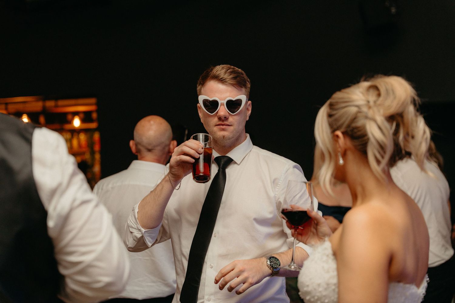 Wedding guests enjoying drinks and conversation during an indoor reception celebration.