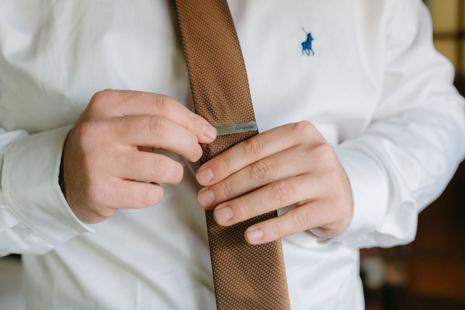 Getting ready details show white dress shirt and blue accessories.