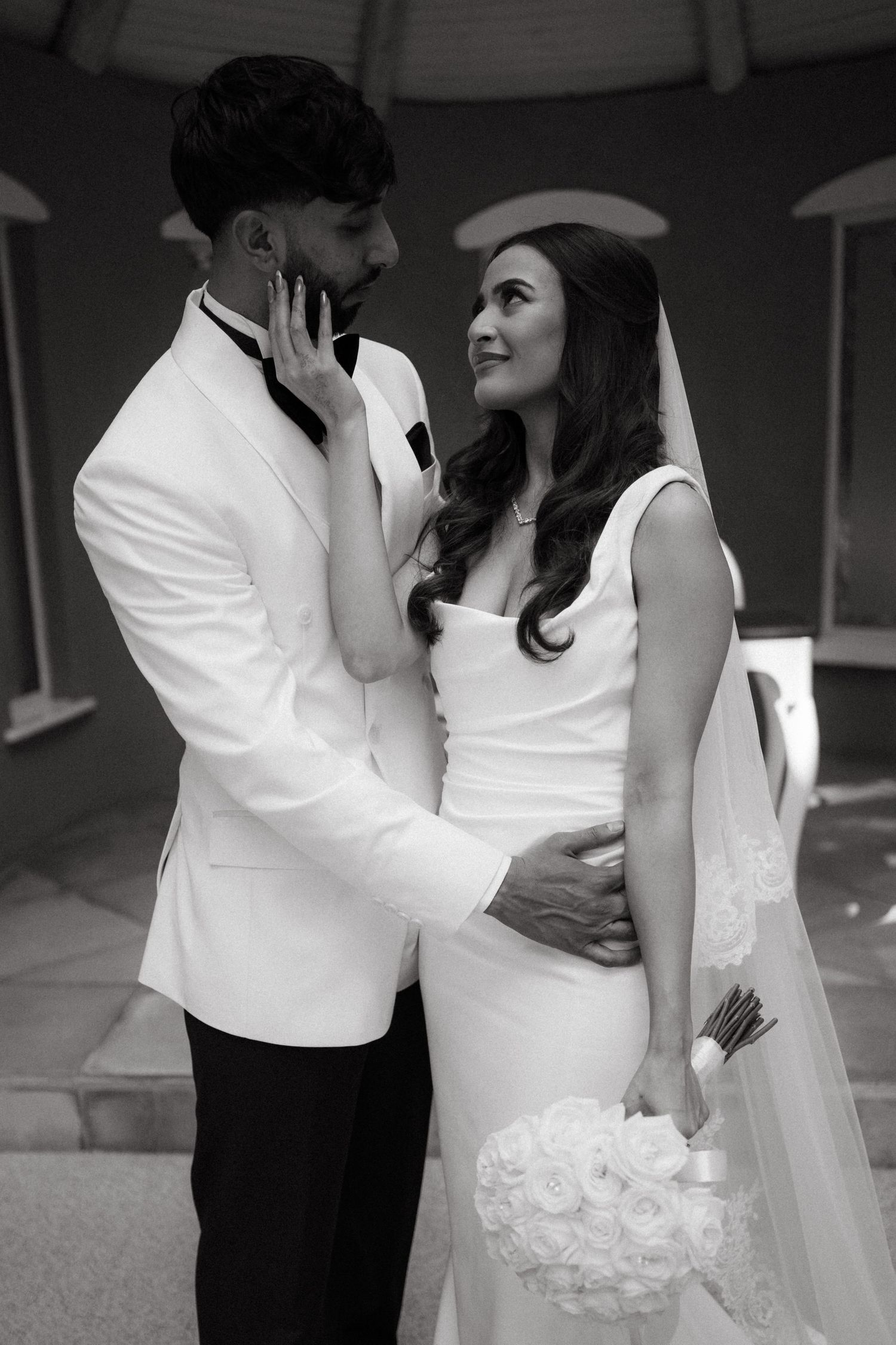 Black and white portrait of a wedding couple sharing an intimate moment.
