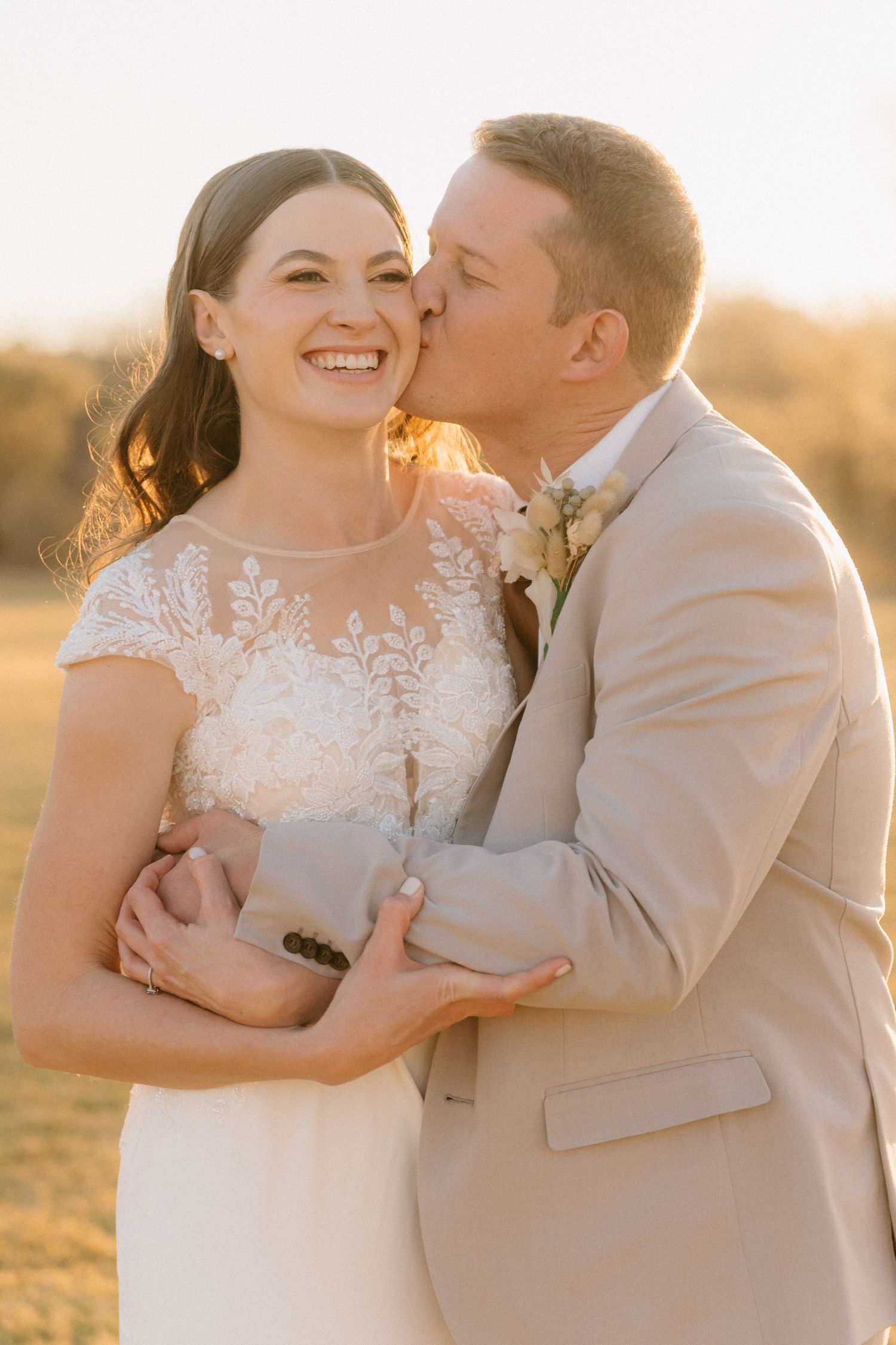 A tender moment between newlyweds captured in warm sunset lighting.