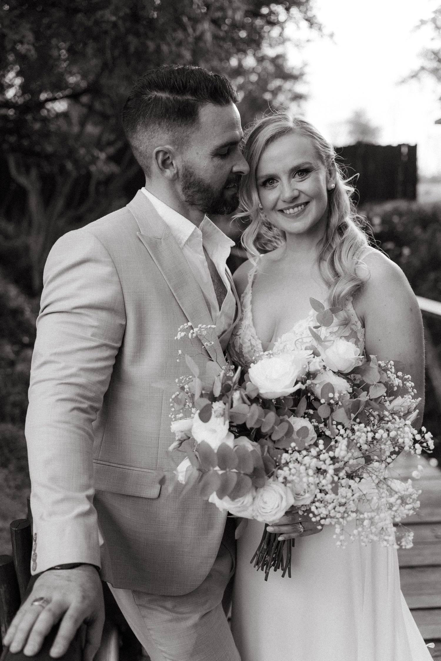 A romantic wedding portrait featuring a couple with a beautiful floral bouquet.