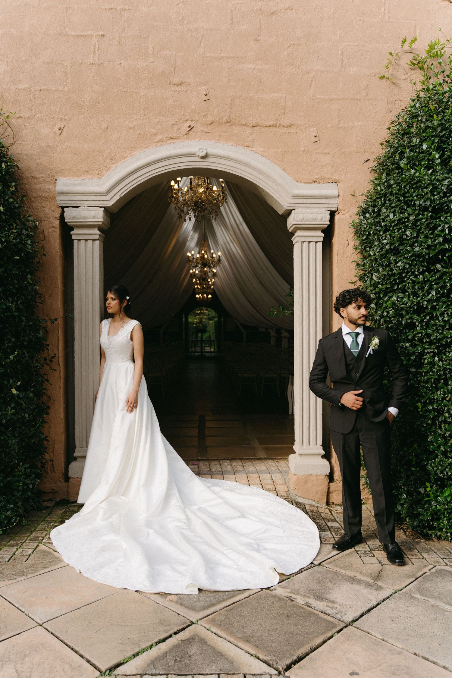 Bride and groom pose separately in arched stone doorway at Oakfield Farm in Johannesburg