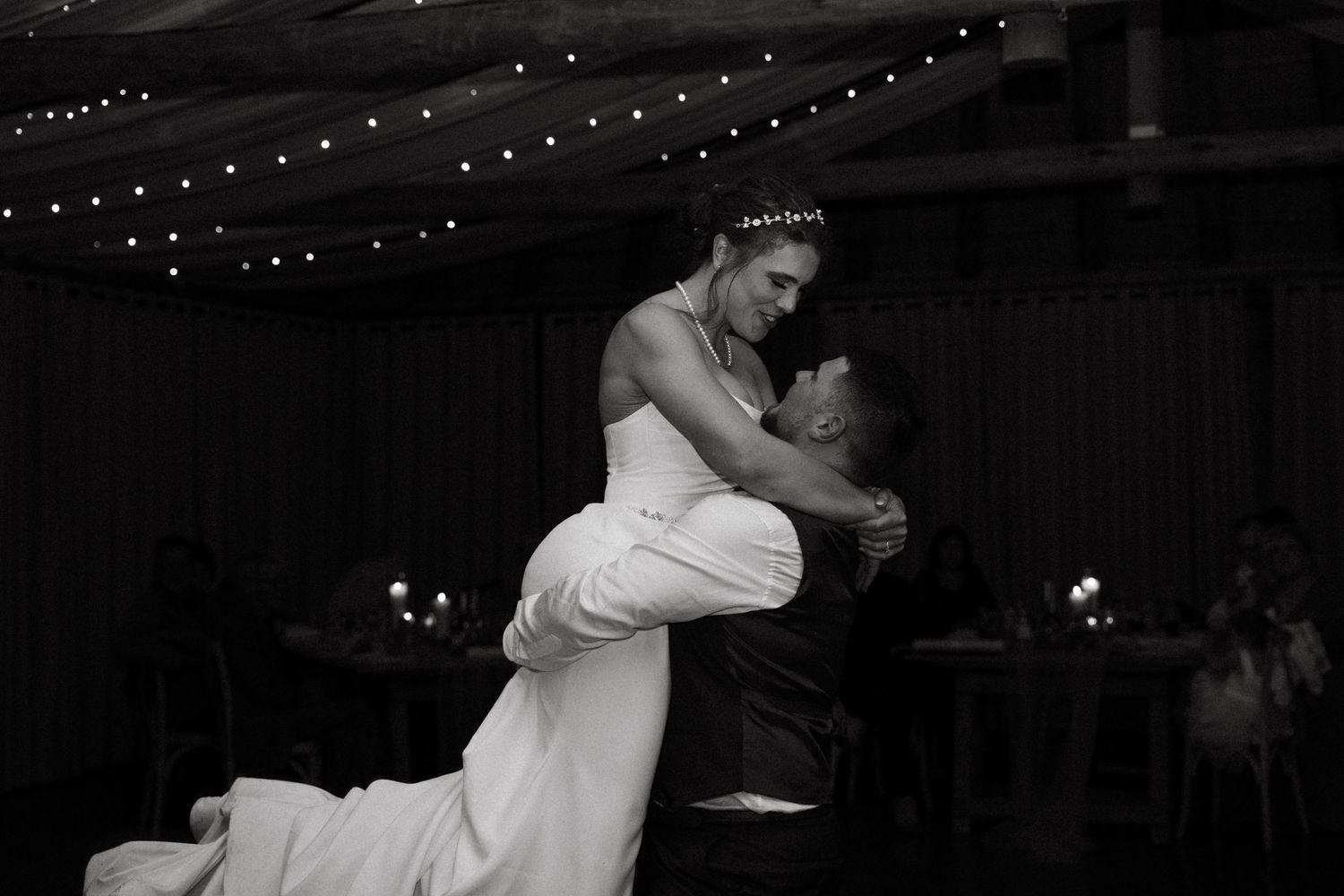 String lights create a romantic ambiance at an evening wedding reception.