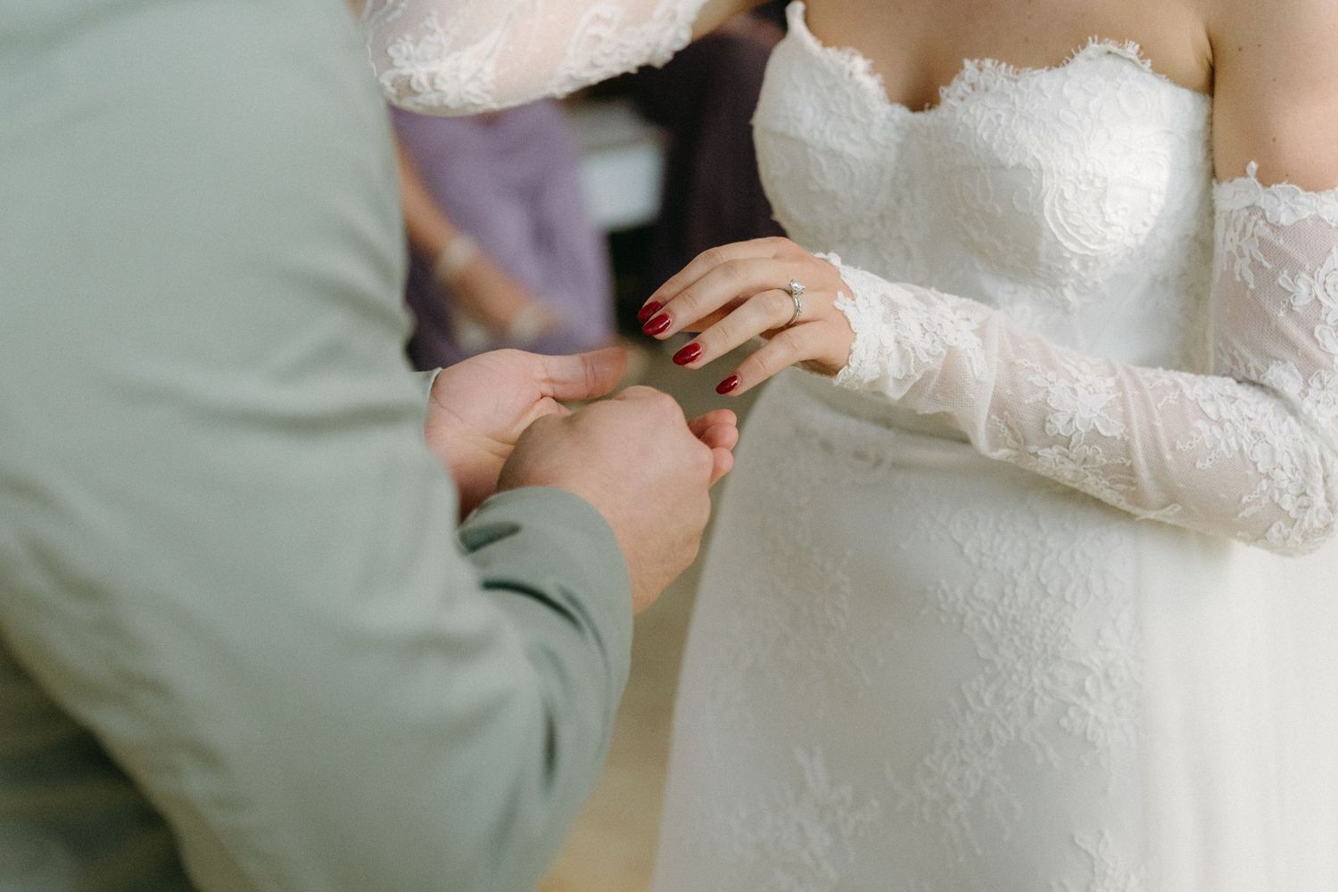 A close-up shot of a couple exchanging rings during a wedding ceremony.