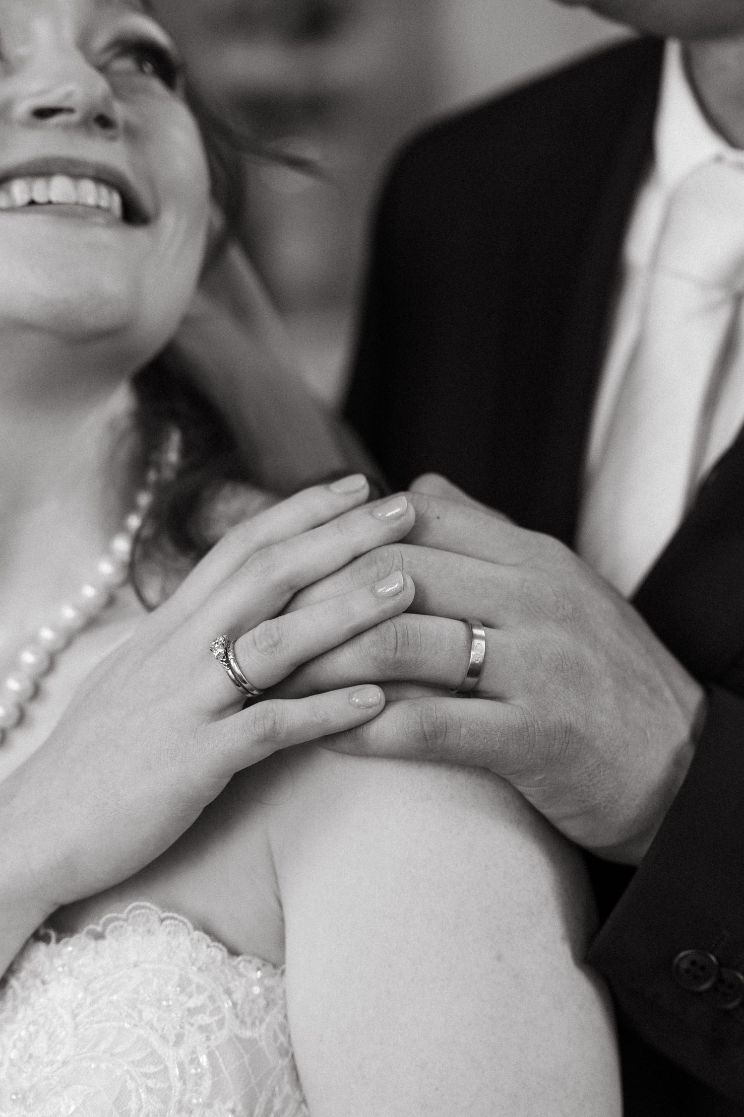 Black and white wedding photo series showing close-up details of hands placing rings and tender moments during ceremony.