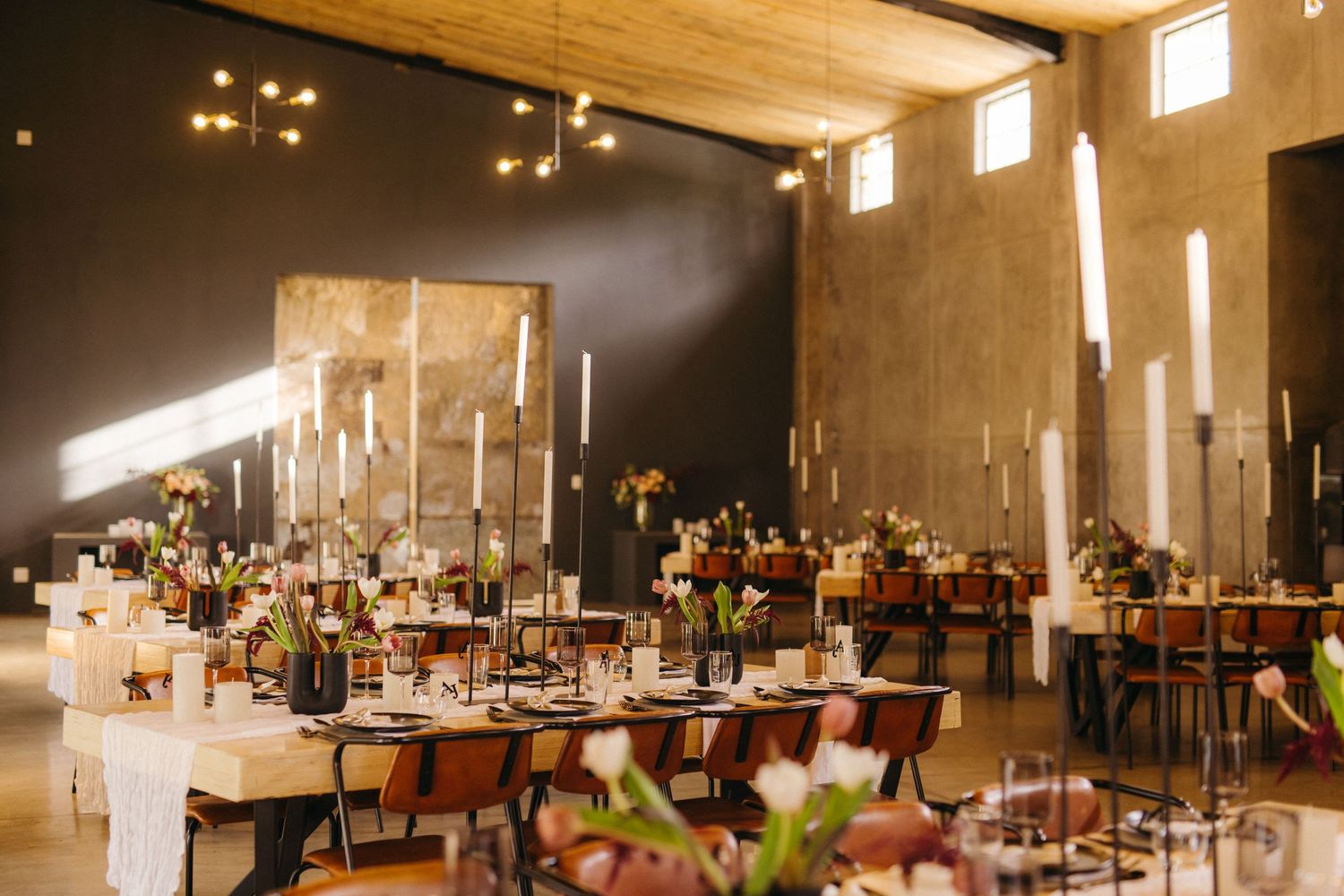 Modern wedding reception venue with dramatic lighting and elegant table settings.