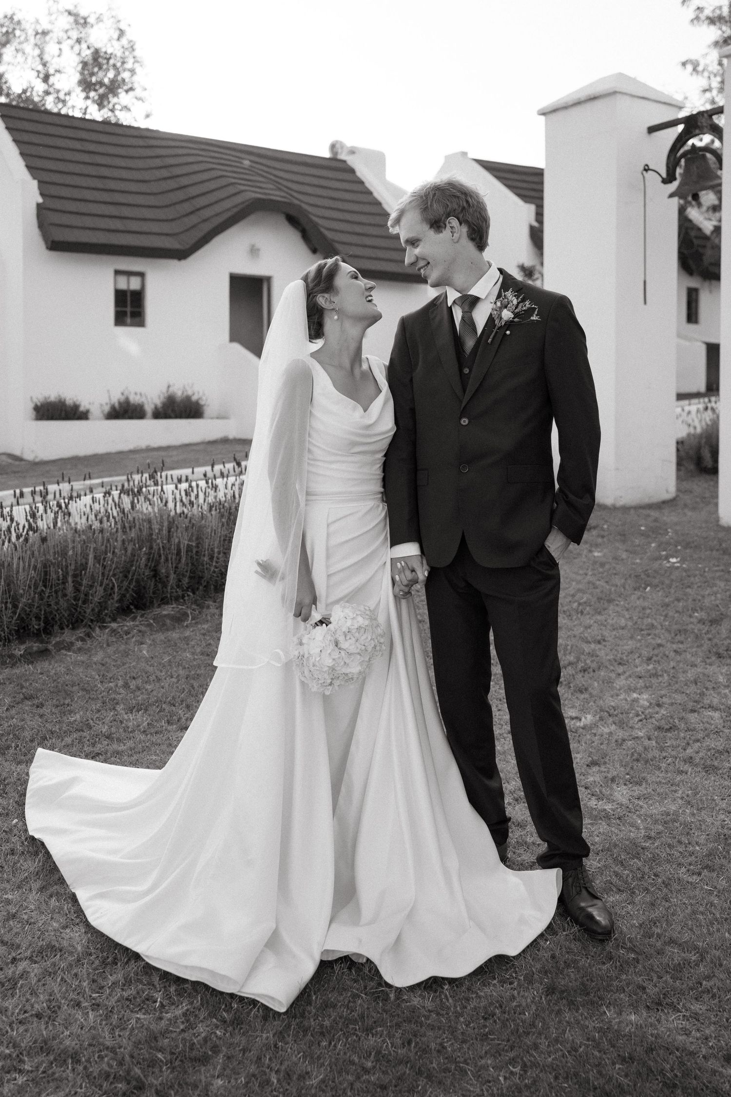 A series of black and white romantic wedding photos showing a couple in formal attire posing together outdoors.