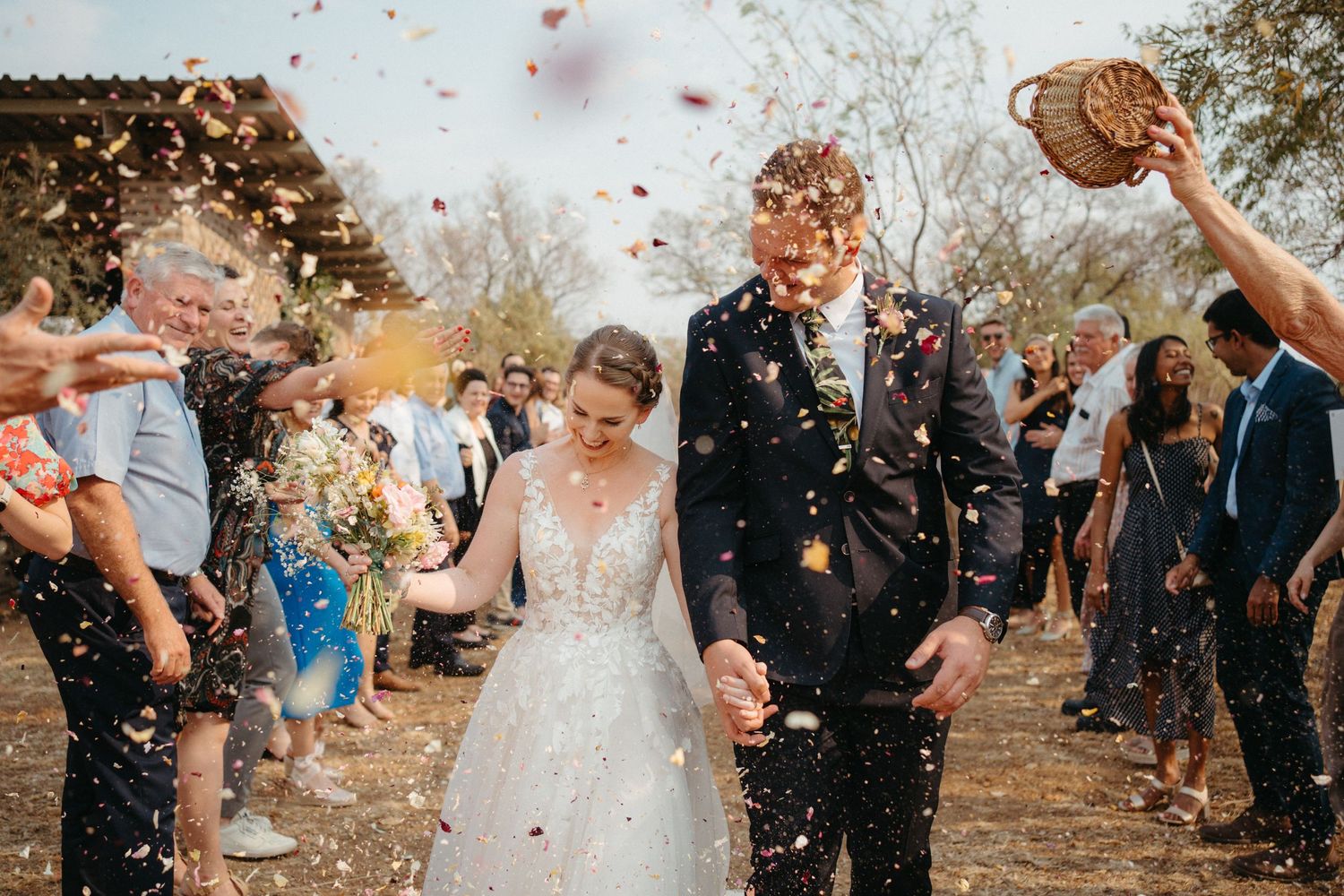 Wedding couple walks through confetti at their Bushveld wedding day in Dinokeng
