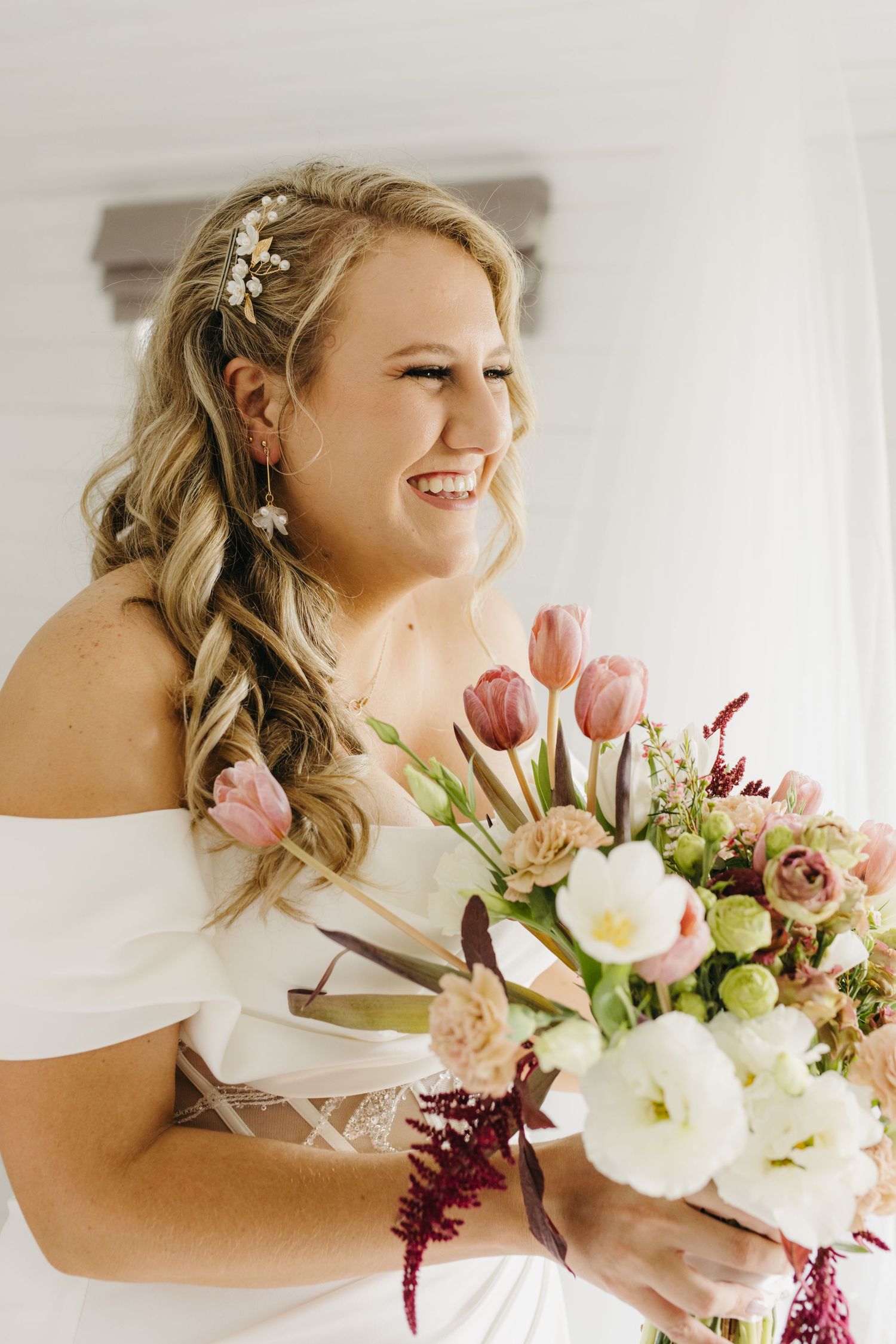 Bridal portrait with romantic bouquet featuring pink tulips and white flowers.