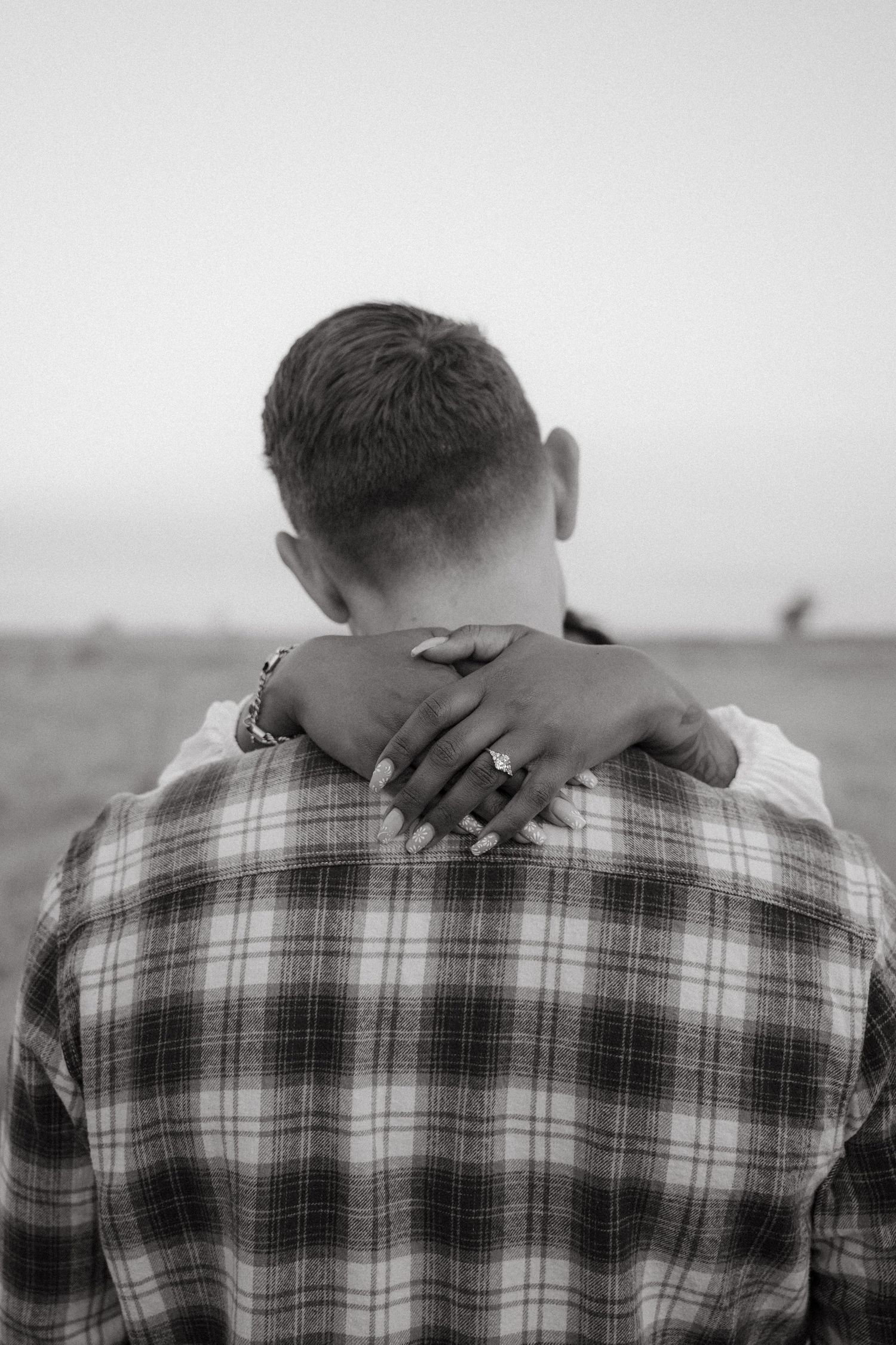 A black and white photo series showing someone in a plaid shirt with their head bowed down in different poses.