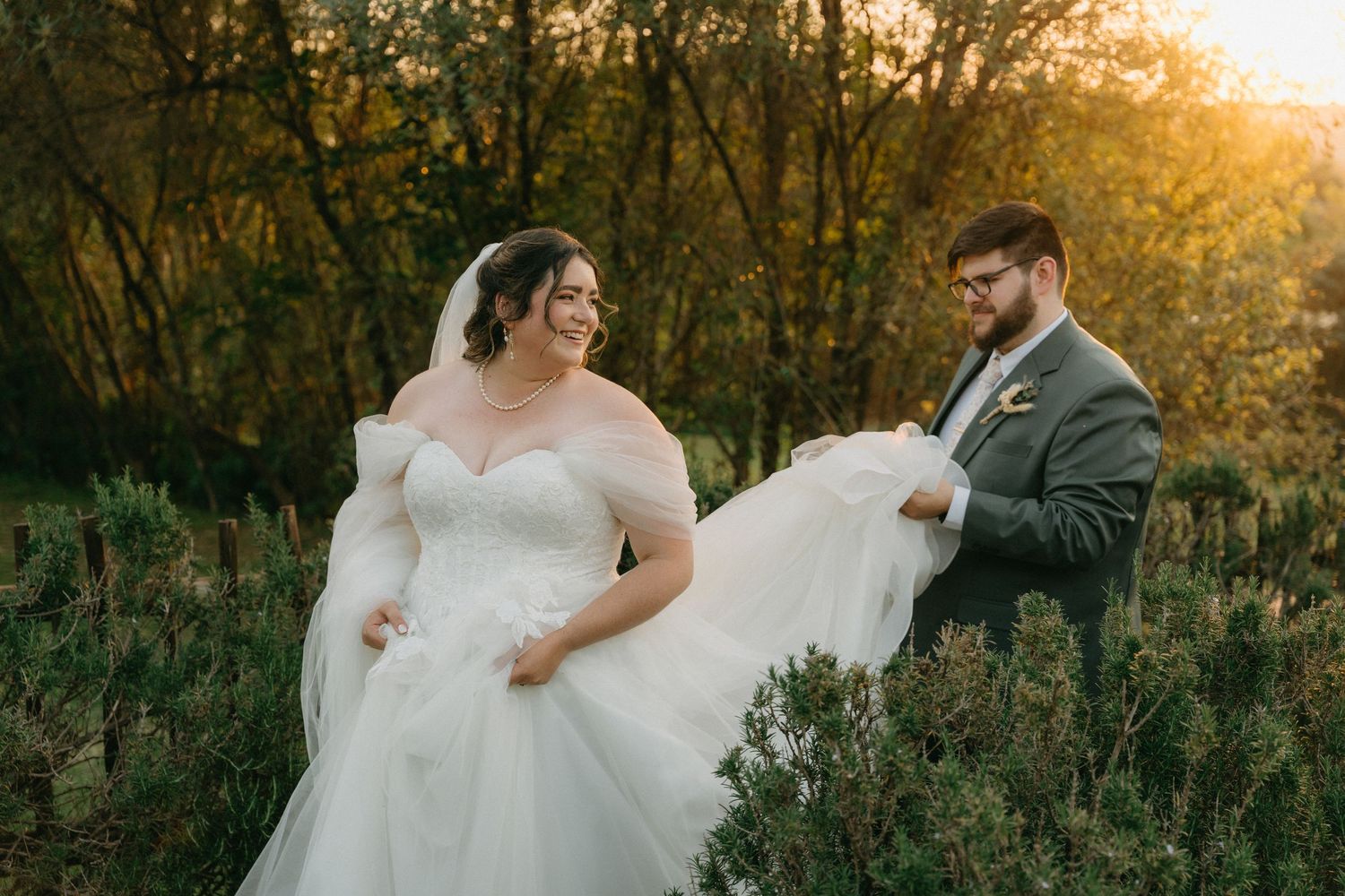 A romantic sunset wedding photoshoot in a rustic outdoor setting with golden hour lighting illuminating the scene.