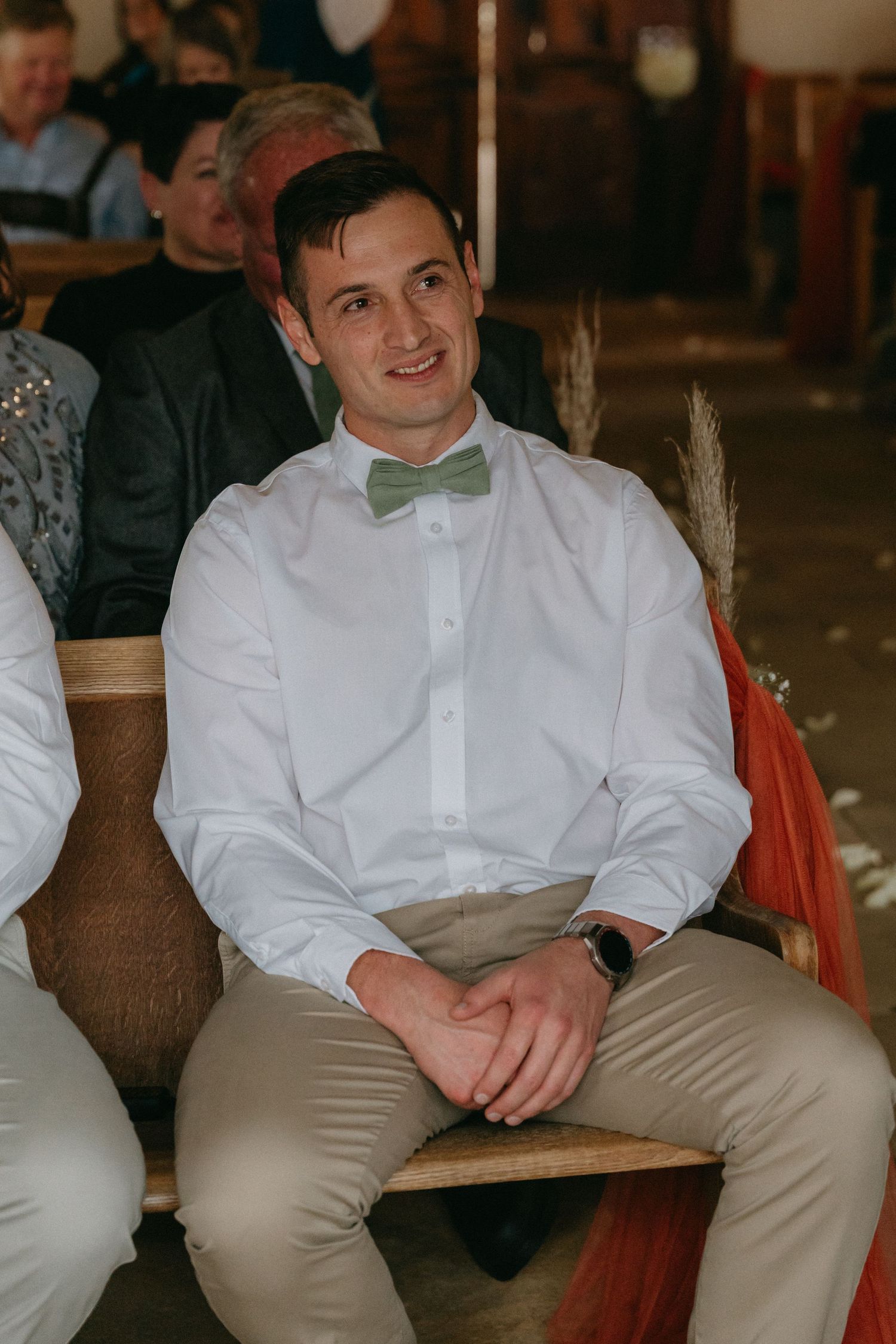Groomsmen in white shirts and khaki pants relax during wedding reception.