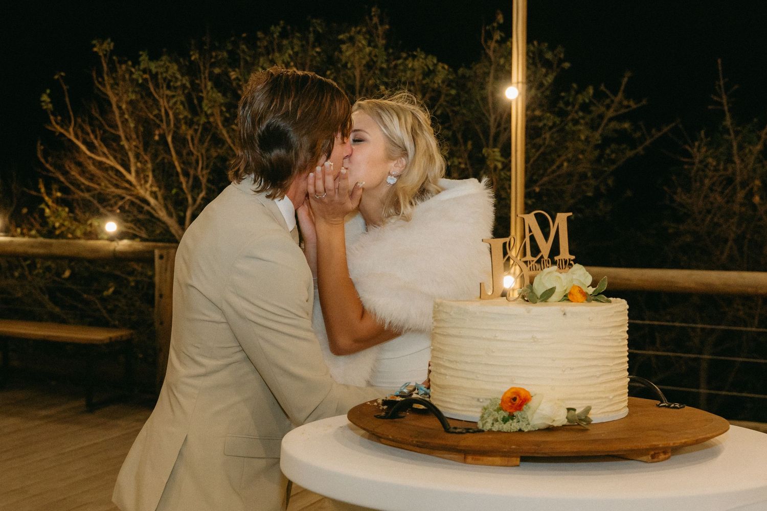 Romantic candlelit wedding reception scene with white cake and ambient lighting.