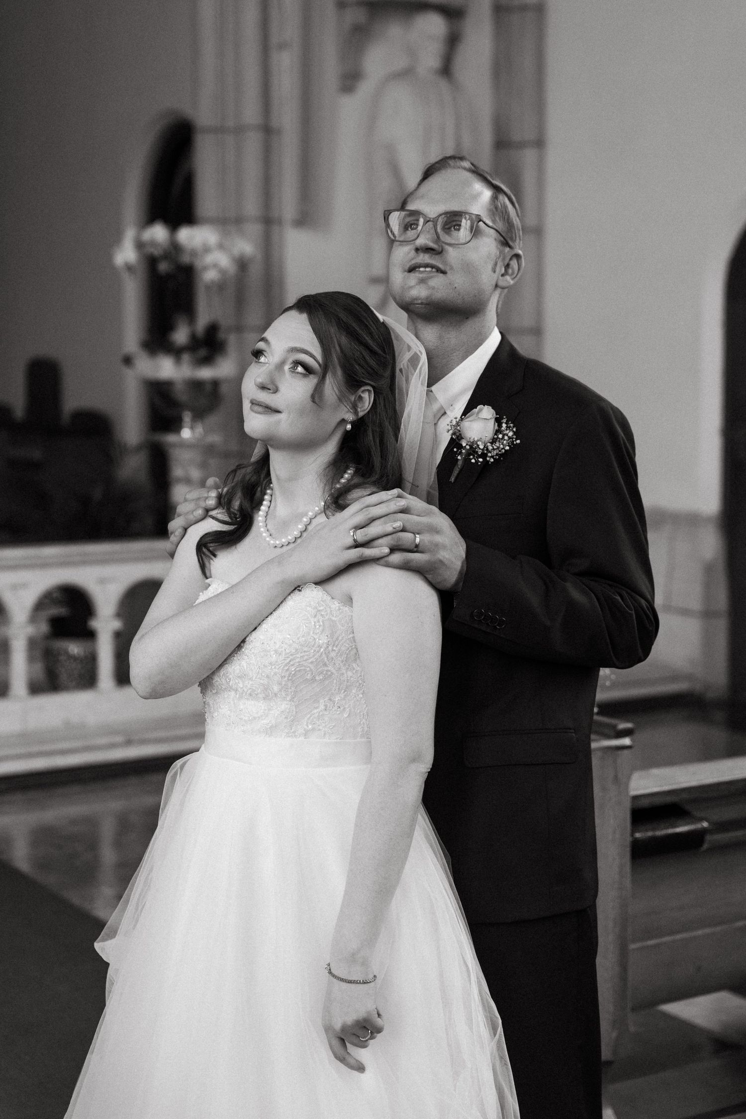 A black and white photo of a bride and groom gazing out a window at their wedding at Nazareth House Chapel in Pretoria