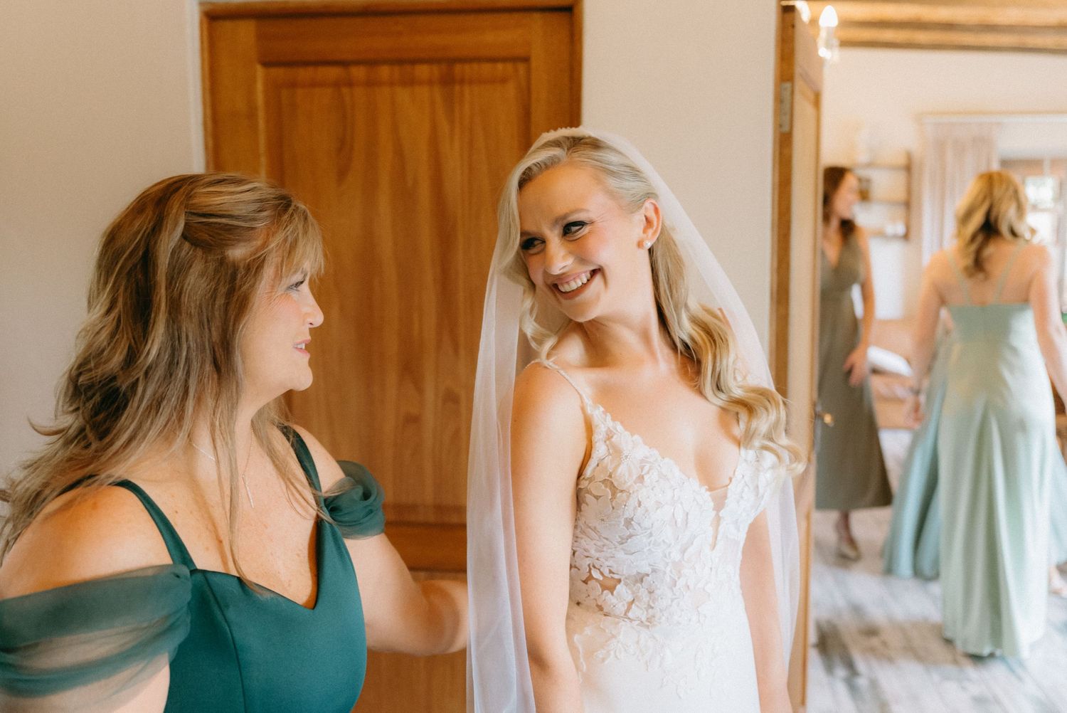 Bridesmaids in soft blue dresses help with wedding preparations.