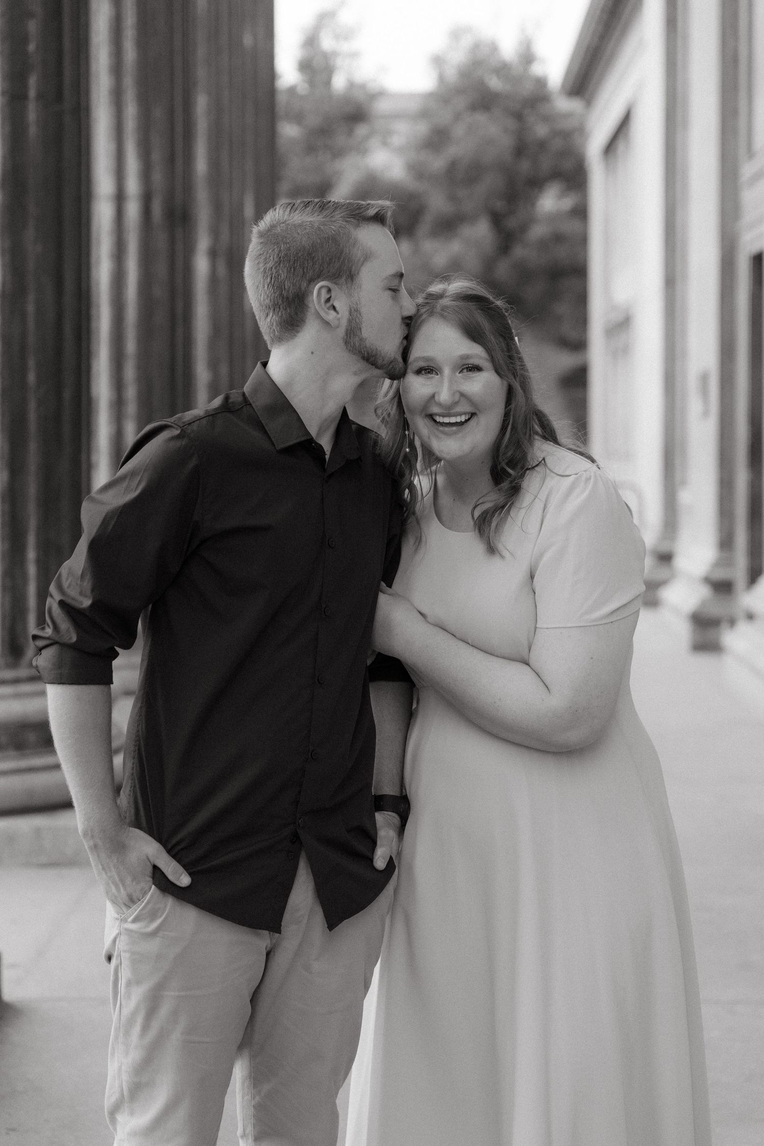 A romantic black and white photo series showing a couple embracing and sharing tender moments on a city sidewalk.