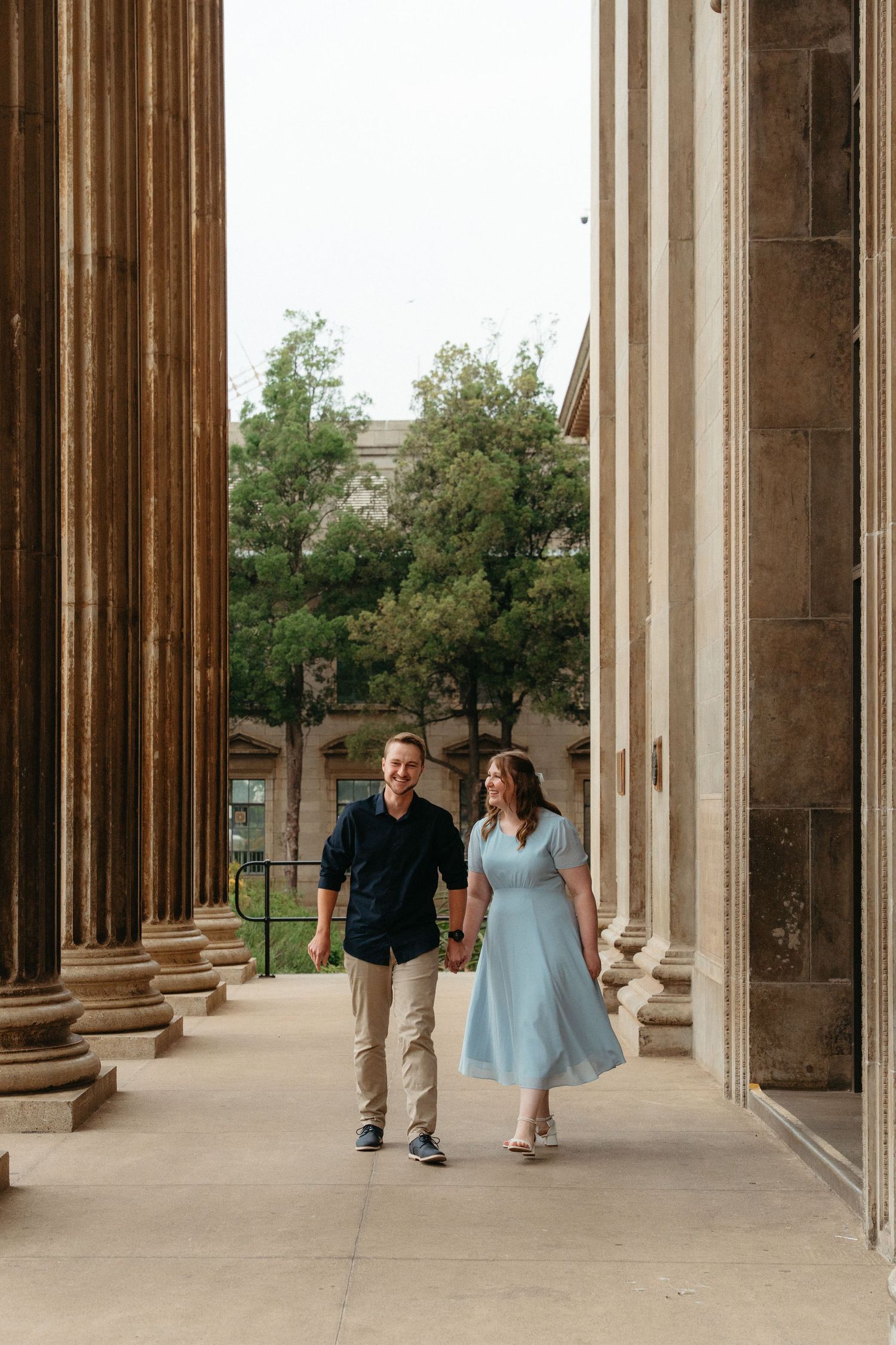 Couple walking together through the stone pillars of the Wits Great Hall