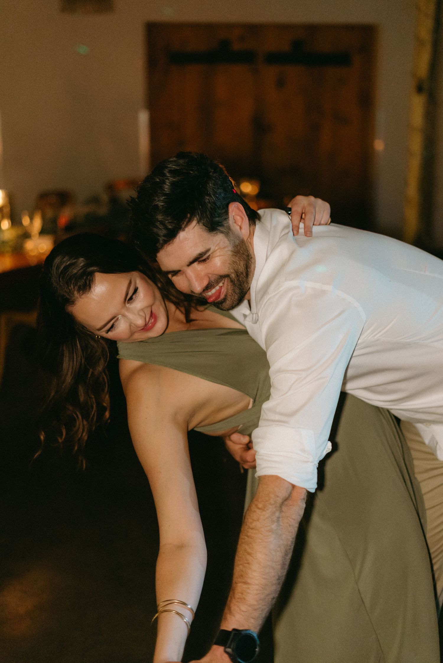 A couple shares a romantic dip while dancing at their wedding celebration.