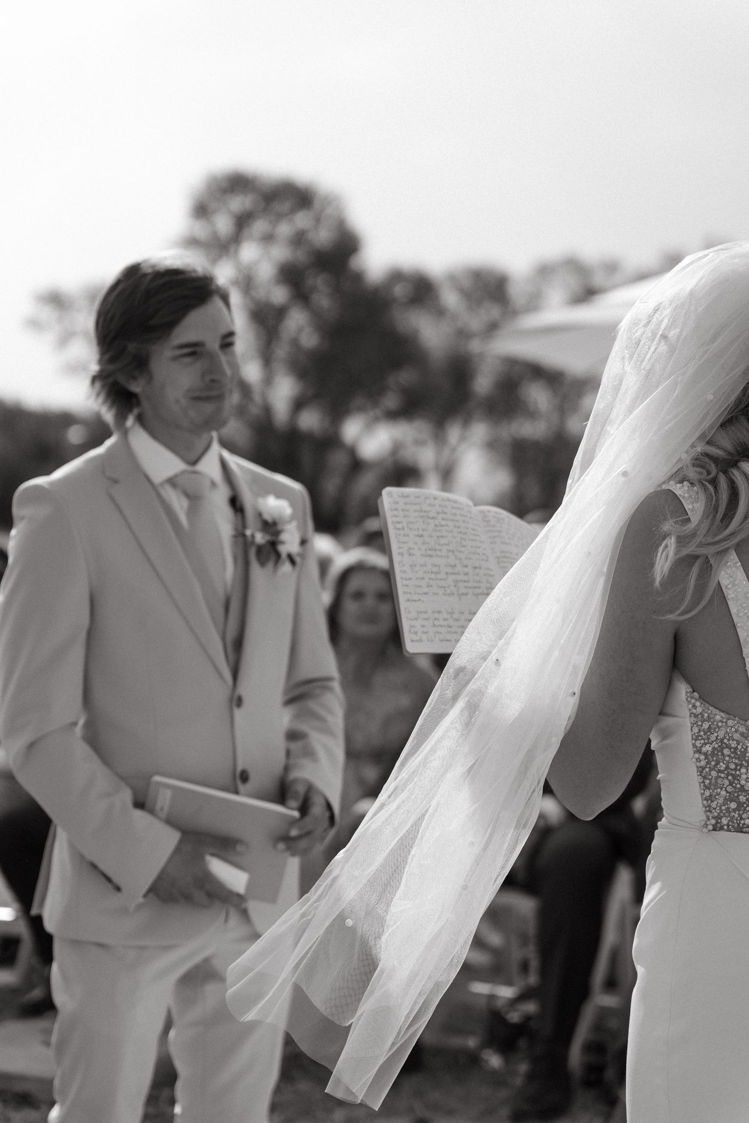 A series of black and white wedding photos showing joyful moments between a couple in formal attire.