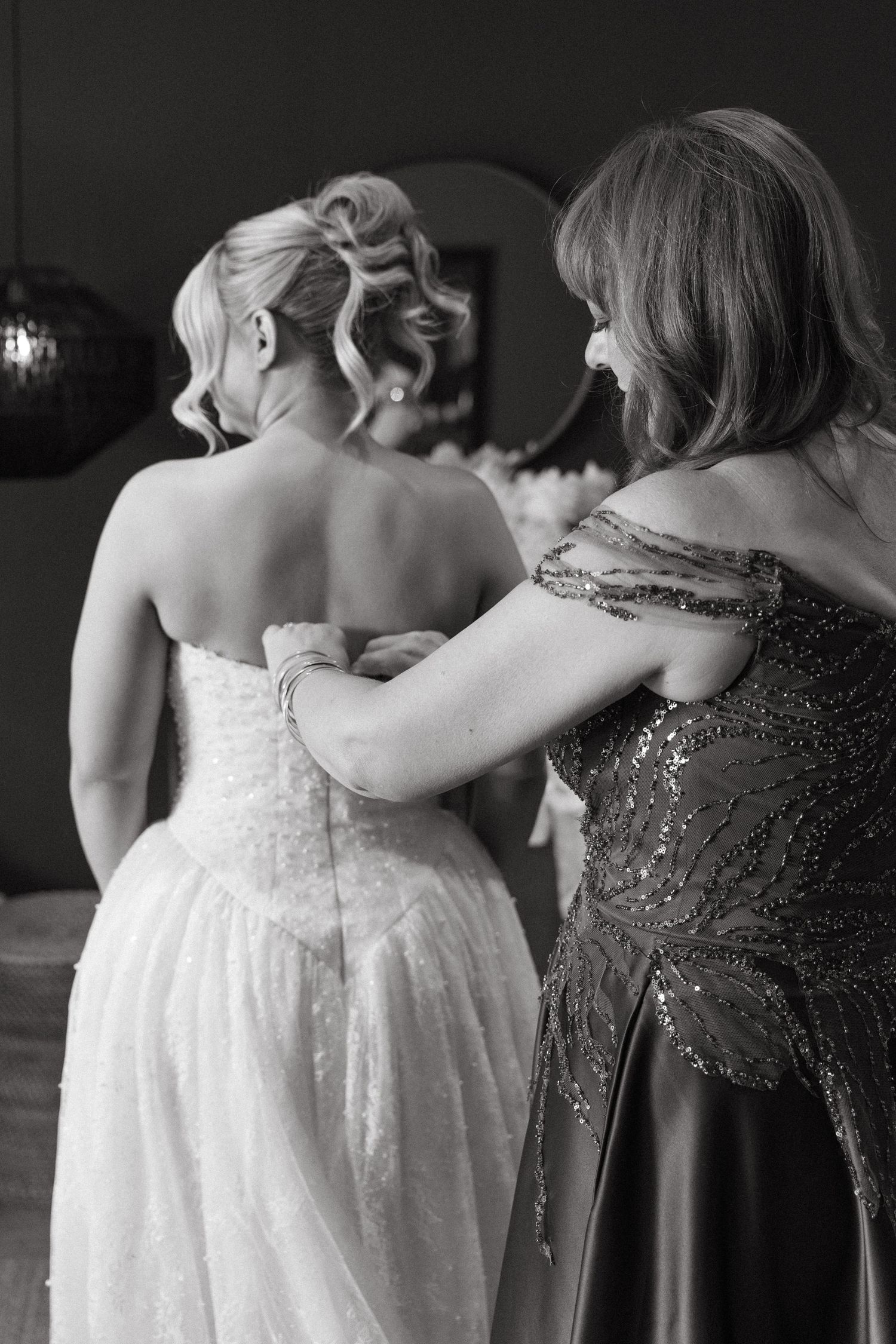 A sequence of black and white photos showing two people in formal dresses embracing in a tender moment.