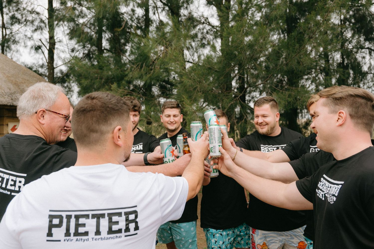 Group of friends celebrating with high fives and energetic gestures outdoors.
