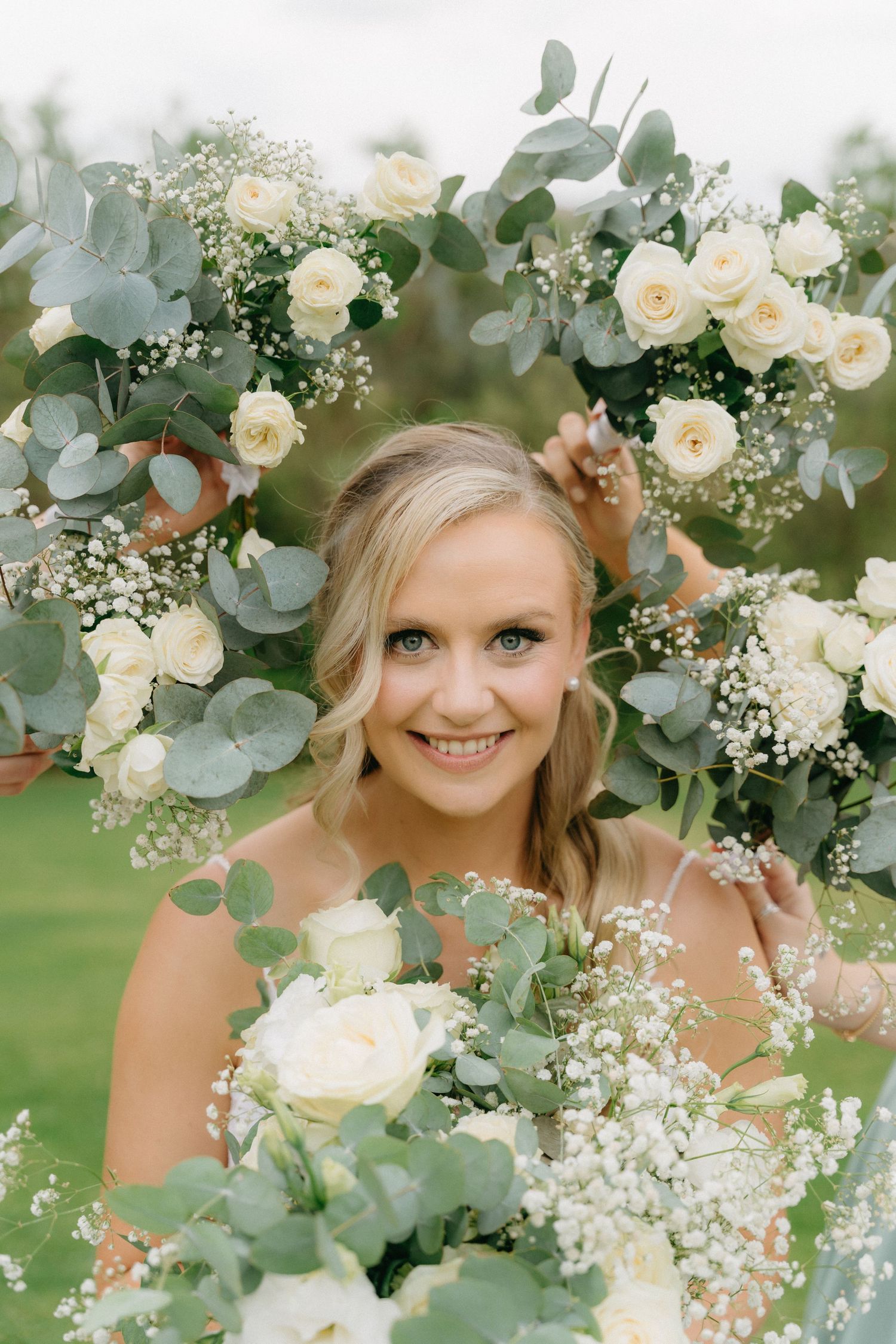 A bridal bouquet of white roses and eucalyptus creates a romantic frame.