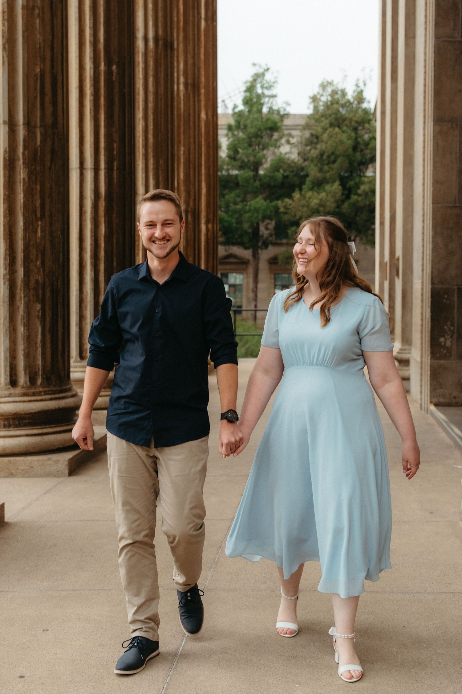 A couple walking together in formal attire through a columned architectural space in Johannesburg