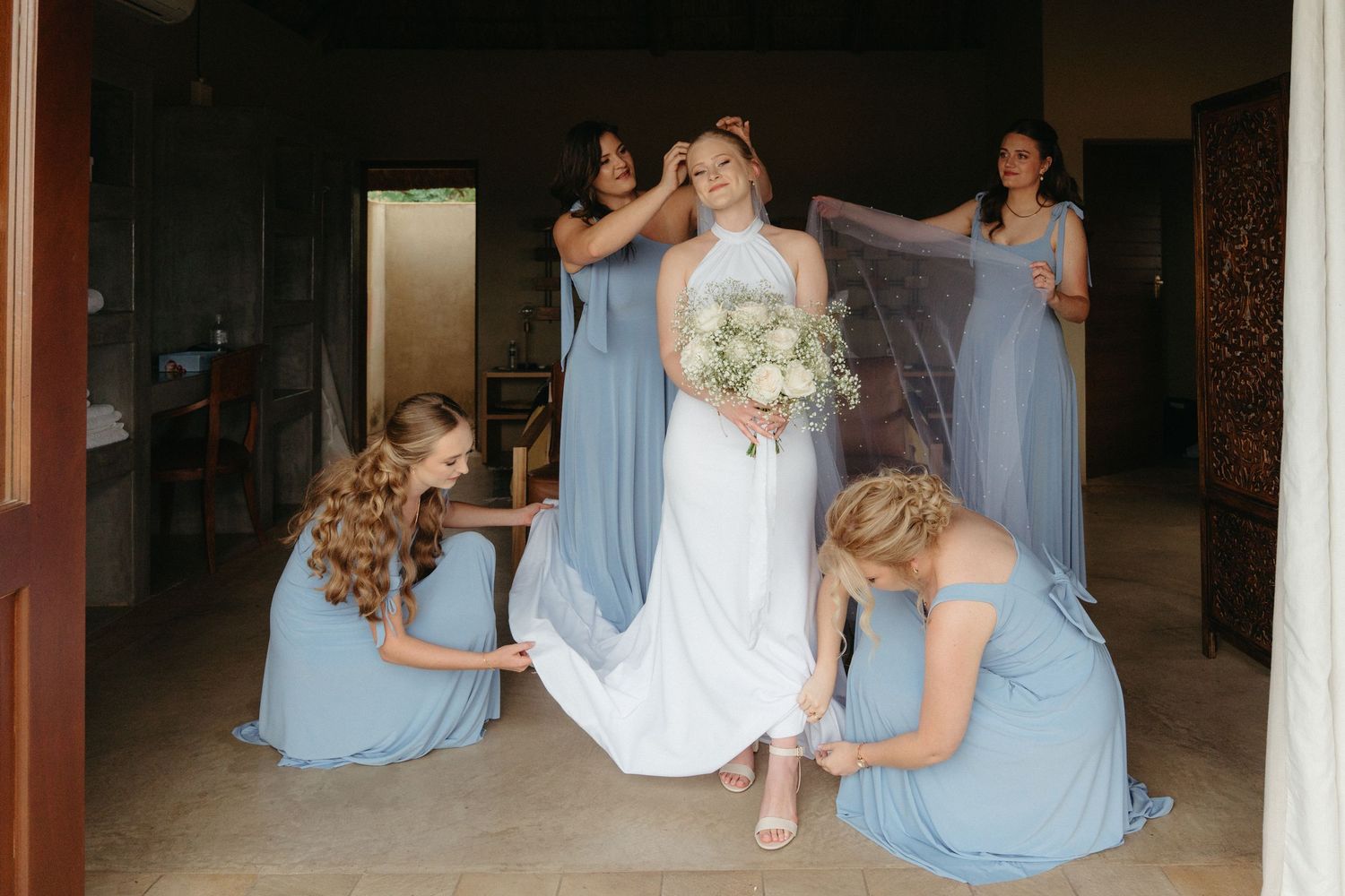 Wedding party gathered in light blue dresses during celebration.